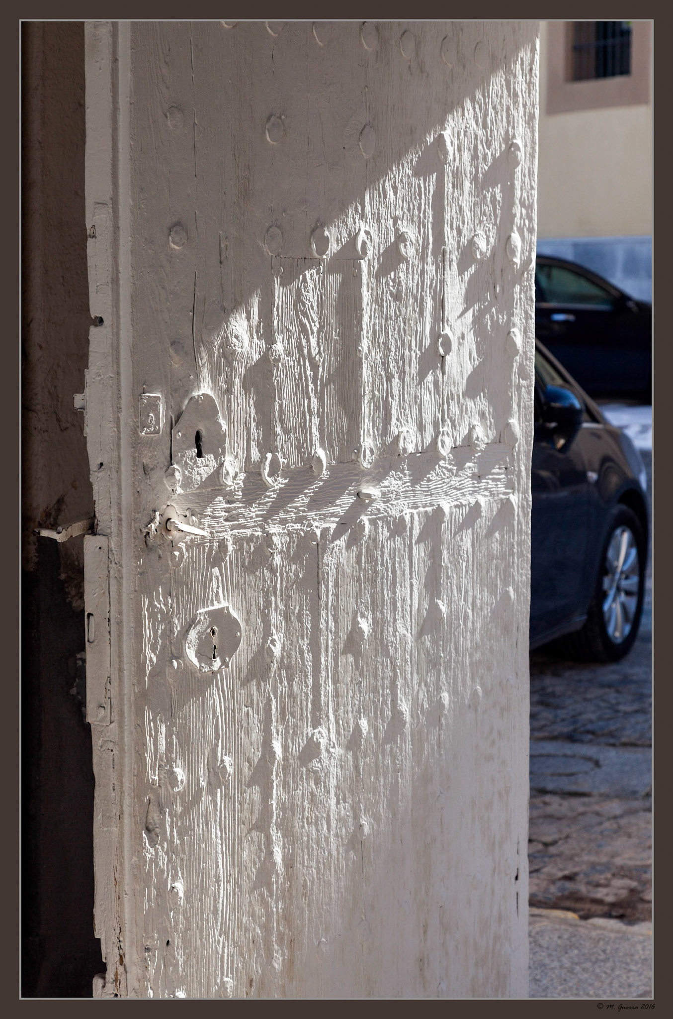 Puerta de madera encalada de blanco en unos antiguos establos de La Granja. Ampliar