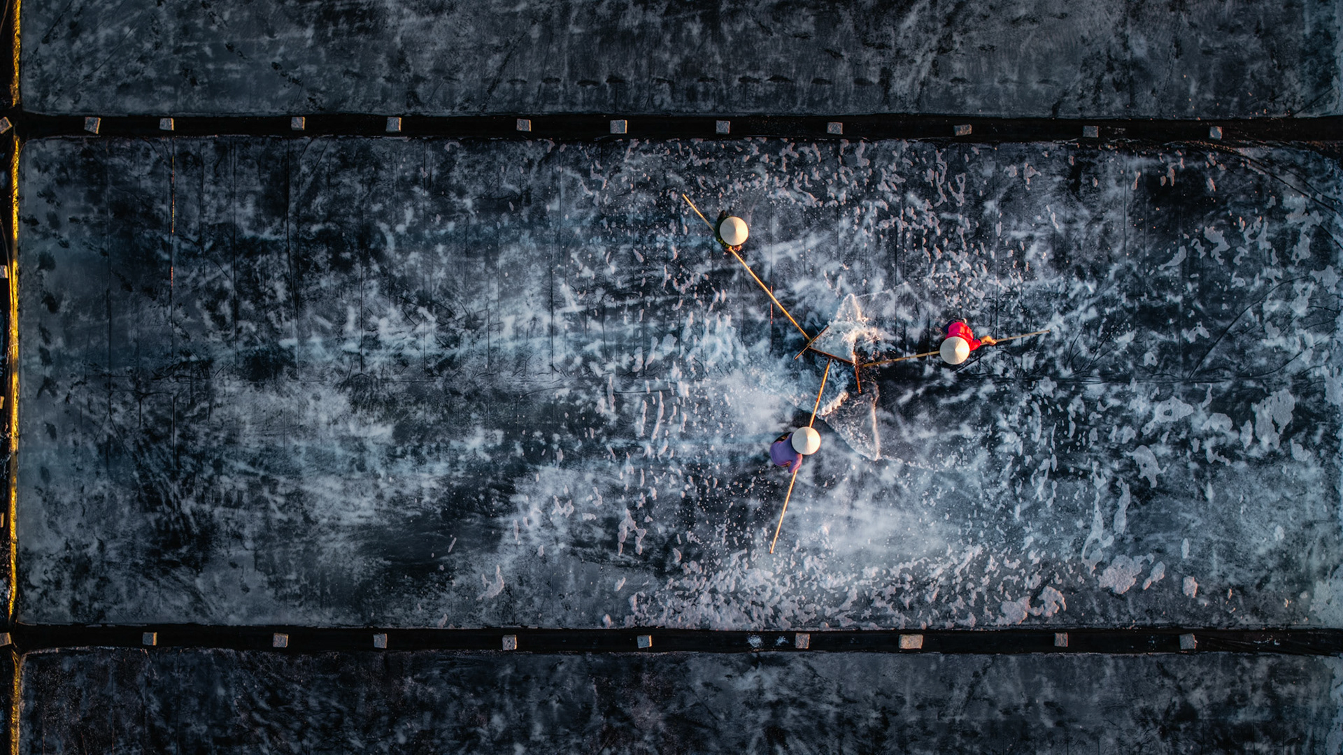 A choreographed moment in the harsh environment of the salt fields, where demanding daily labor meets fine art.