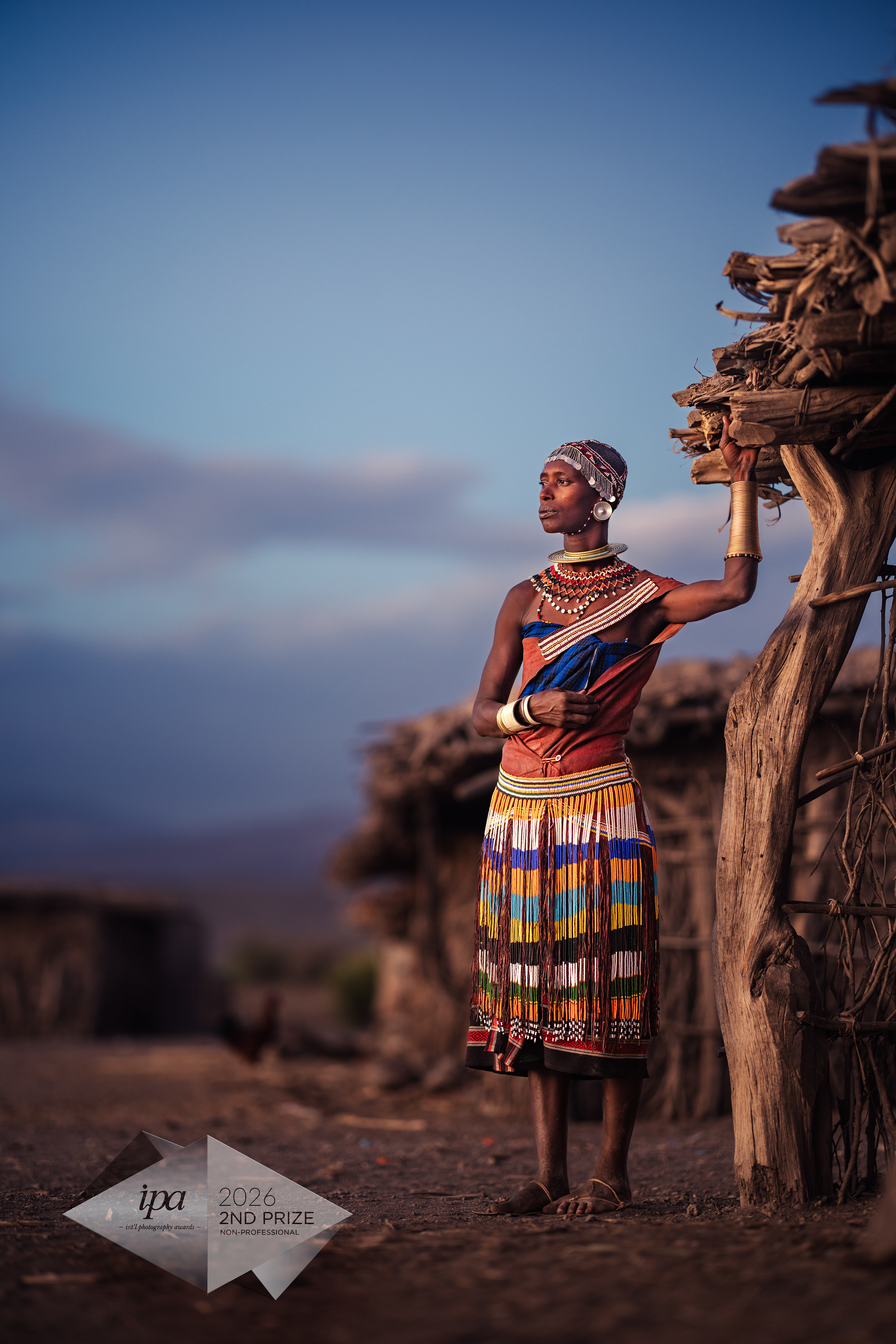 Pride of Datoga: Rift Valley HeritageAs dust settled near Lake Eyasi in Tanzania's Rift Valley, the authentic heartbeat of the Datoga tribe remained. In a village of traditional Datooga huts (Doma), I encountered this remarkable woman. Standing before her home, she carried her heritage in handmade cowhide cloth and intricate brass jewelry crafted with ancestral skill. Her focused expression conveyed a proud, untamed beauty. Through her presence, I witnessed the enduring importance of a Datoga woman as the timeless guardian of her ancient culture. 