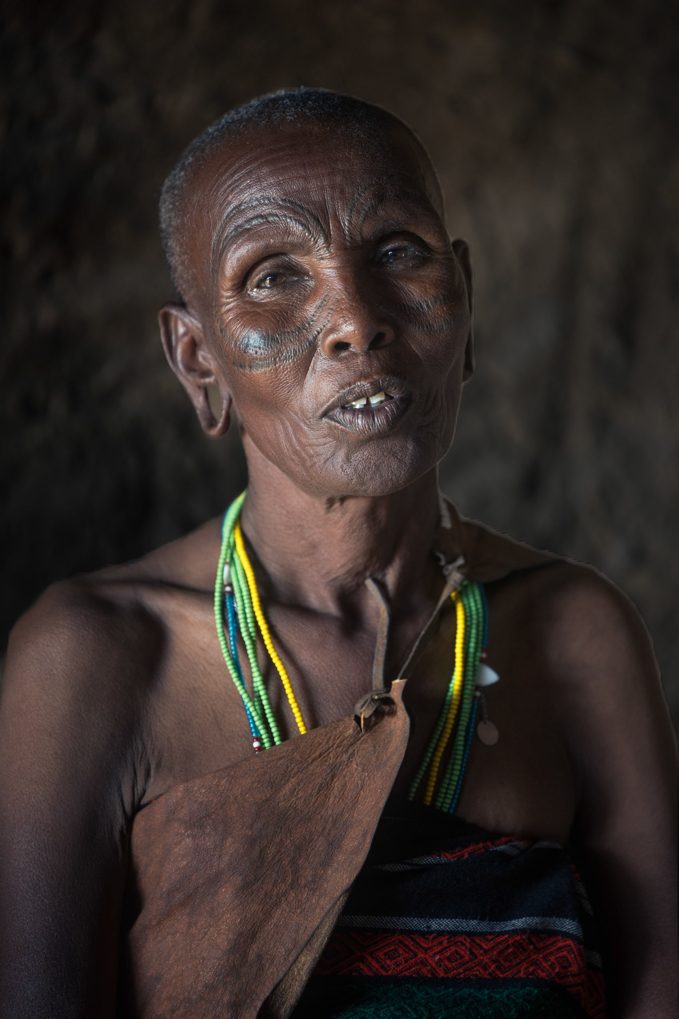 Wisdom Etched in Time — A powerful close-up of a Datoga matriarch, where traditional scarification marks around her eyes tell a story of identity and endurance. These marks are not just ornamentation but a symbol of tribal belonging and the resilience required to thrive in the harsh Tanzanian landscape.