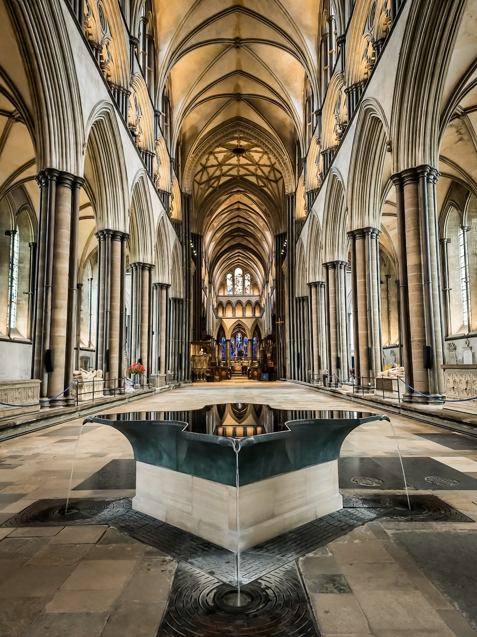 The surface of the water lying in Salisbury Cathedral's font mirros the ancient gothic ceiling high above