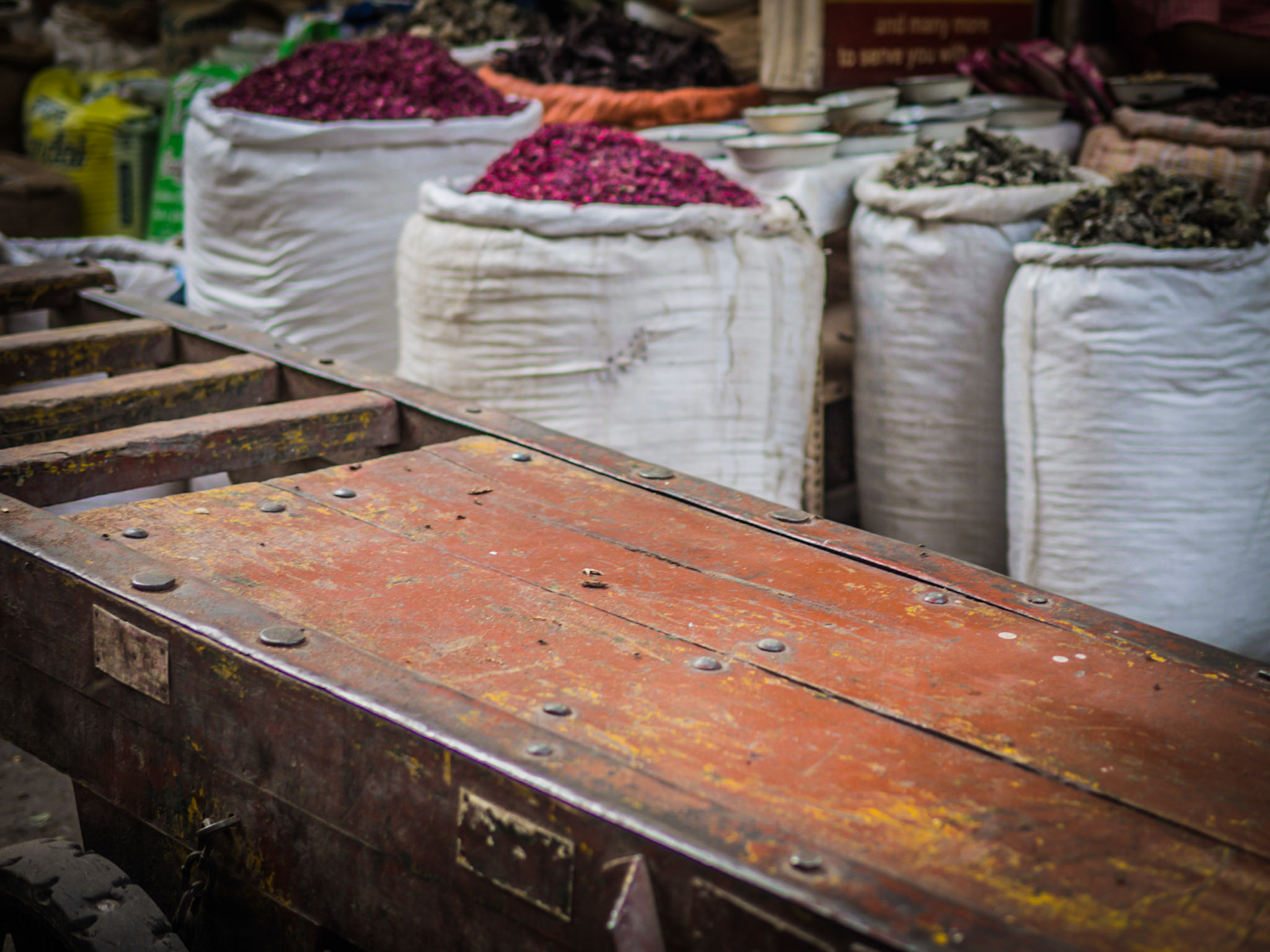 At the end of the working day, a porter's barrow lies empty before sacks of colourful spices one of the markets in the Chandni Chowk district of New Delhi