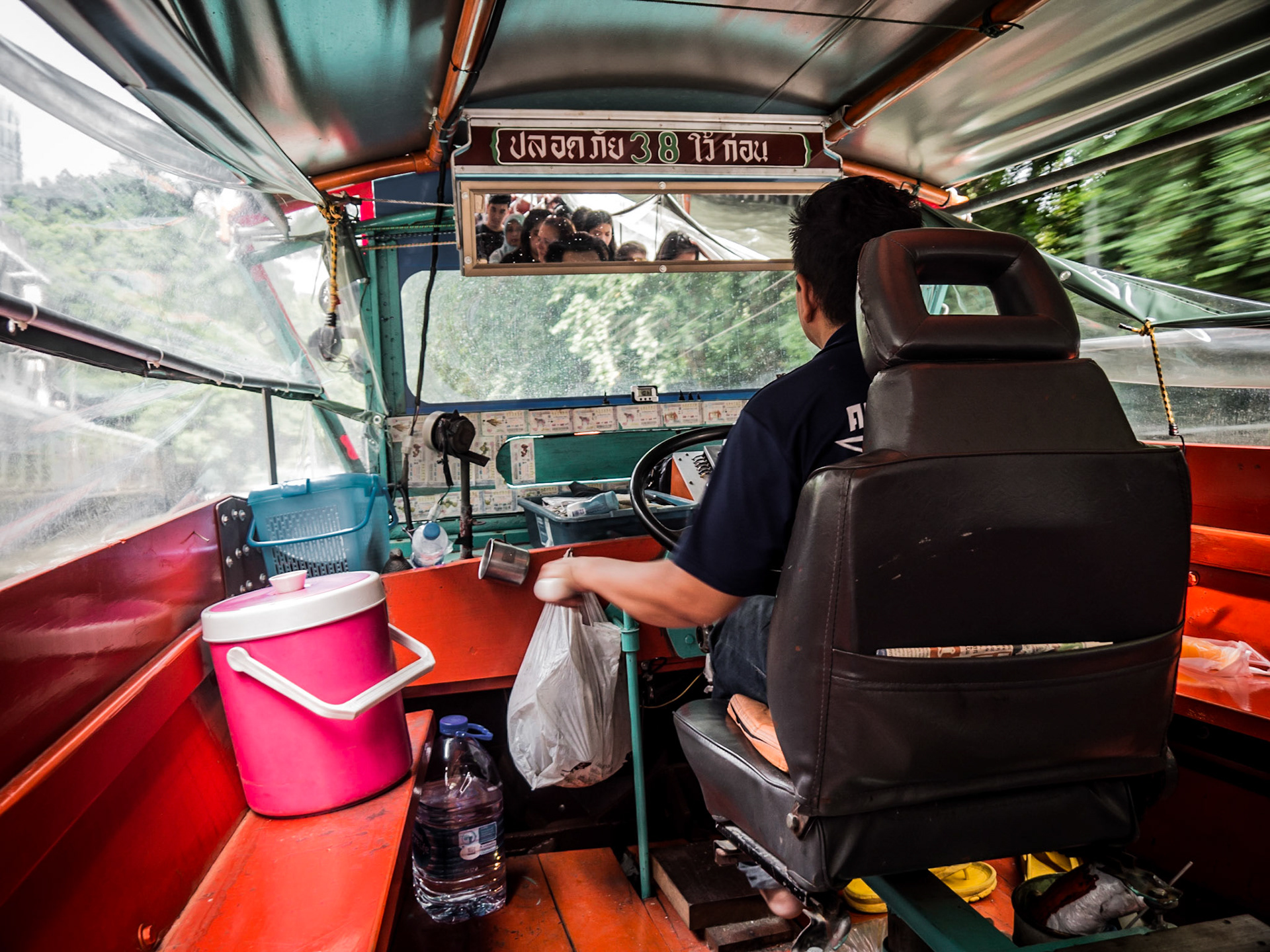 A river bus speeds along one of the many narrow canals in central Bangkok, Thailand