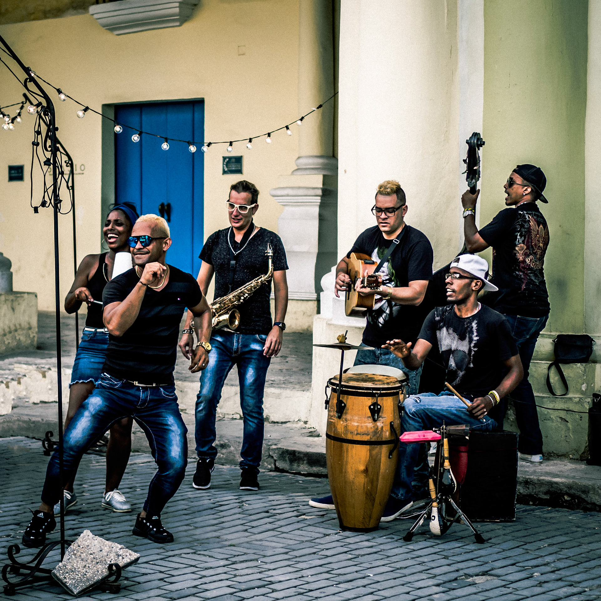 Confident members of a street band encourage tourists to dance in the streets of Havana, Cuba