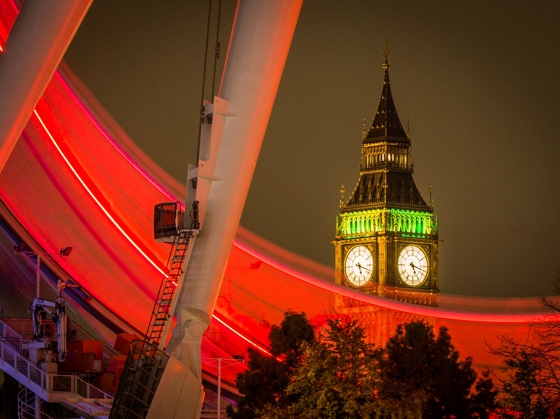 Trails of light from the London Eye pass in front of Big Ben
