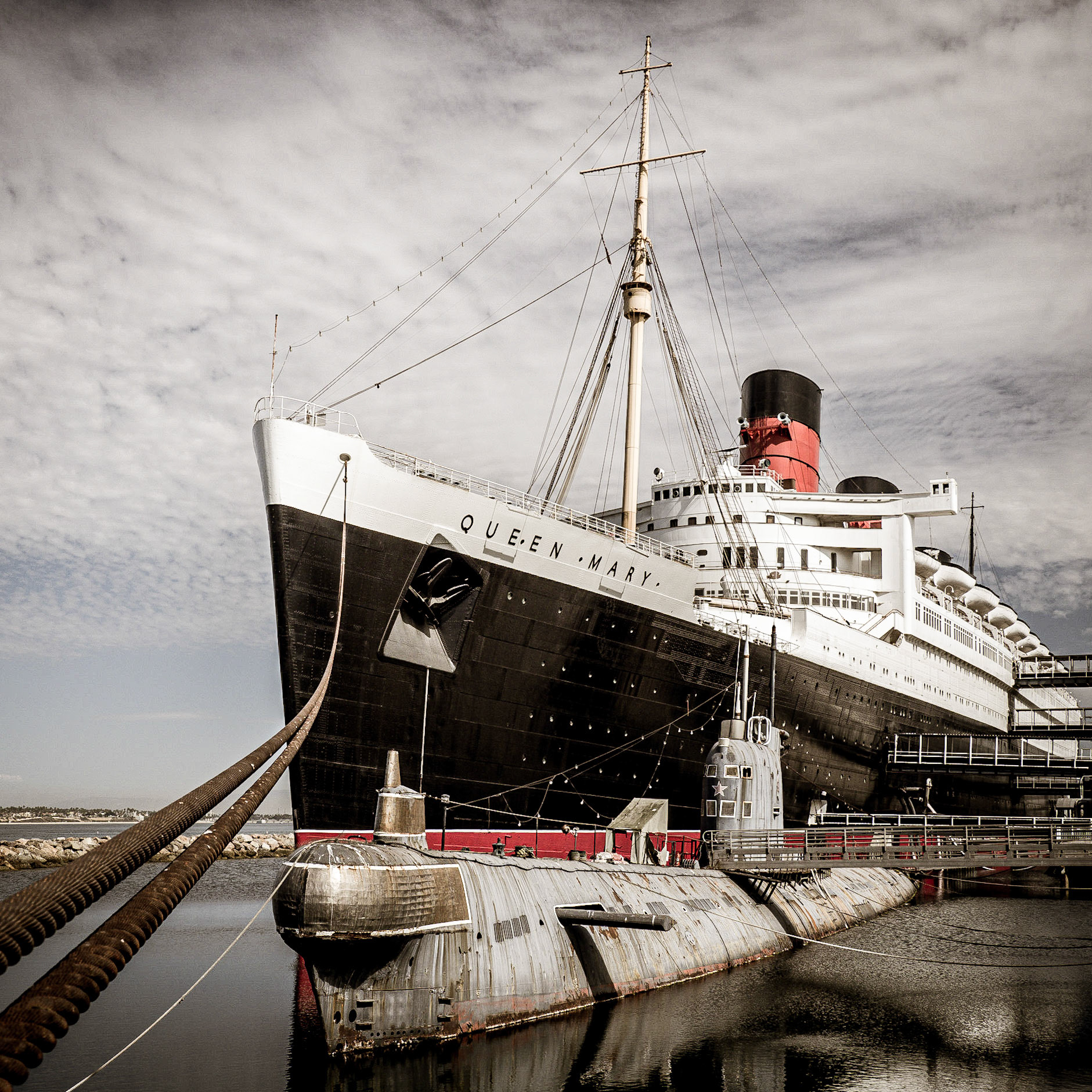 The cruise liner Queen Mary laid up on the shores of Long Beach in California, nestled against a defunct Russian submarine