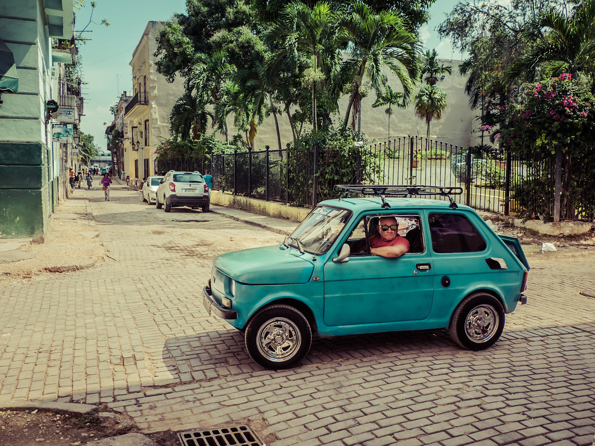 A man sits at a crossroads whilst observing events down the street in Havana, the Cuban capital