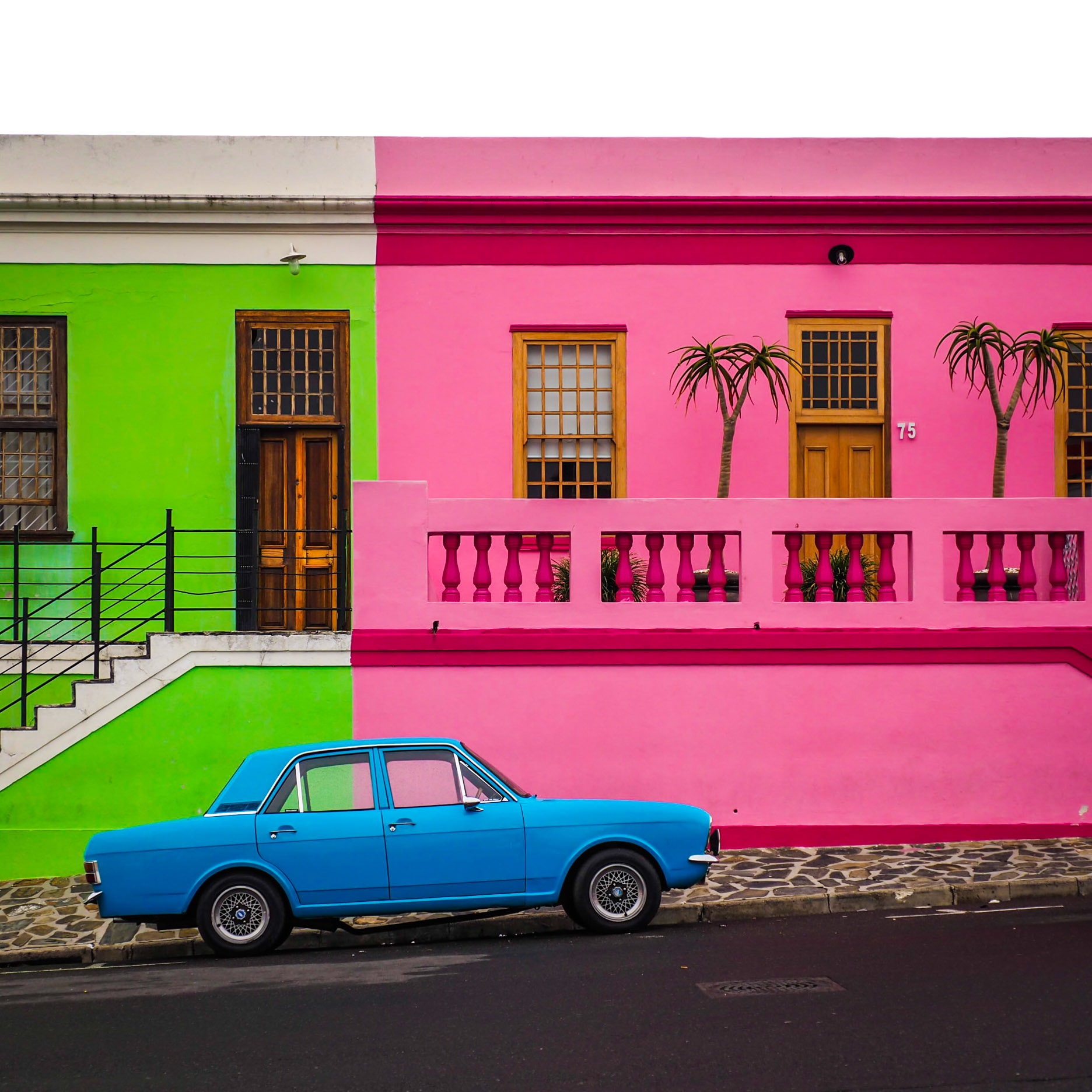 A lone car sits on a colourful street in the Bo-Kaap district of Cape Town, South Africa