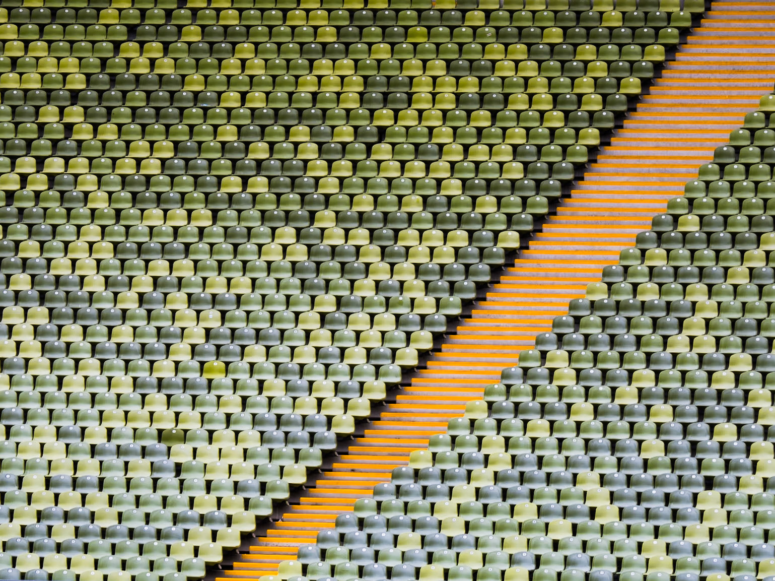 A set of steps carve their way through a bank of green seats in the main Olympic stadium in Munich