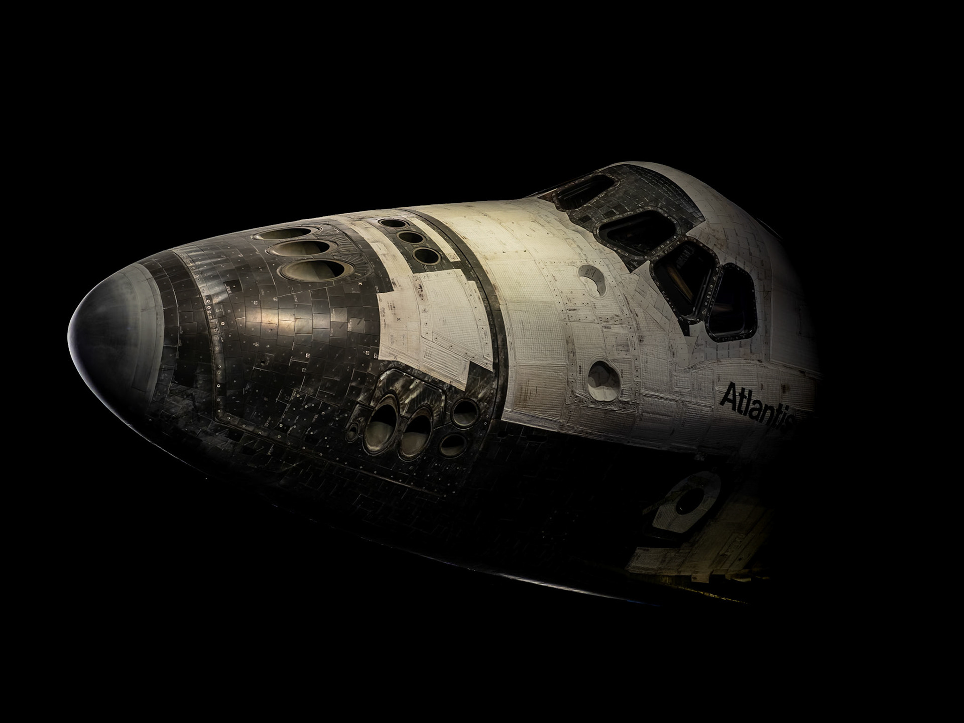 The nose of the space shuttle Atlantis looms out of the darkness at the Kennedy Space Center at Cape Canaveral in Florida