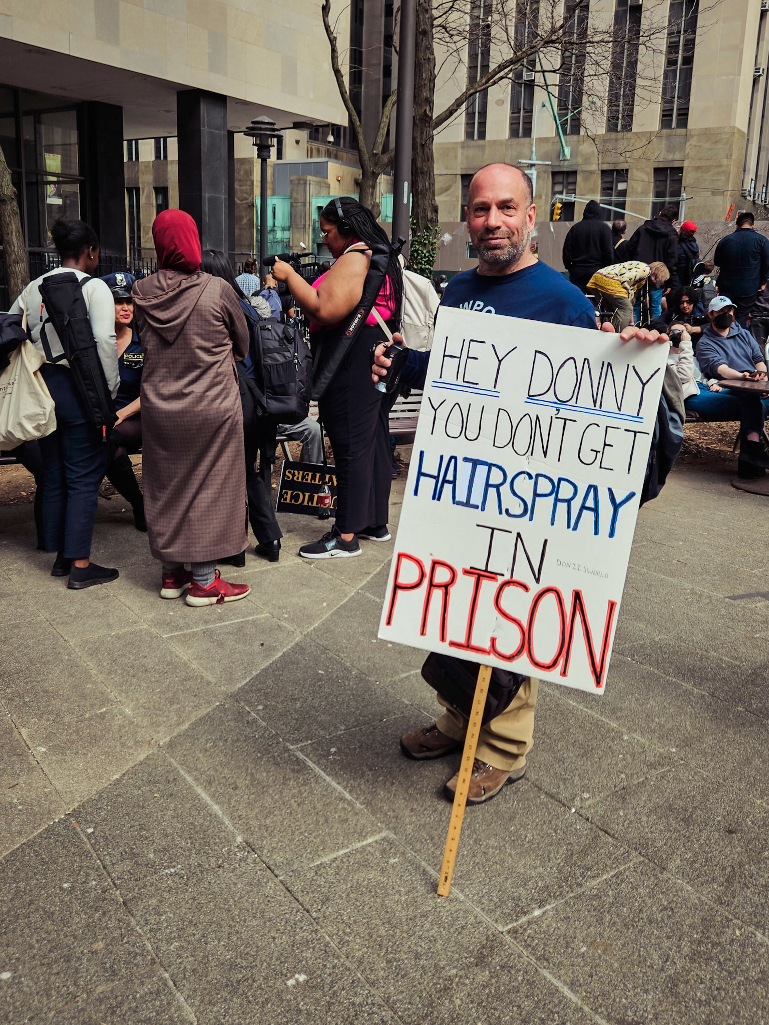 An anti-Trump protester displays an ironic placard outside a New York courthouse whilst former President Donald Trump is arraigned inside