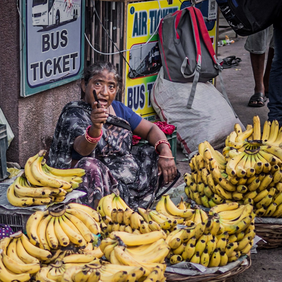 A street-seller doesn't take kindly to her photograph being taken as she sells bananas to commuters in fron of Old Delhi train station, in the Chandni Chowk district of New Delhi