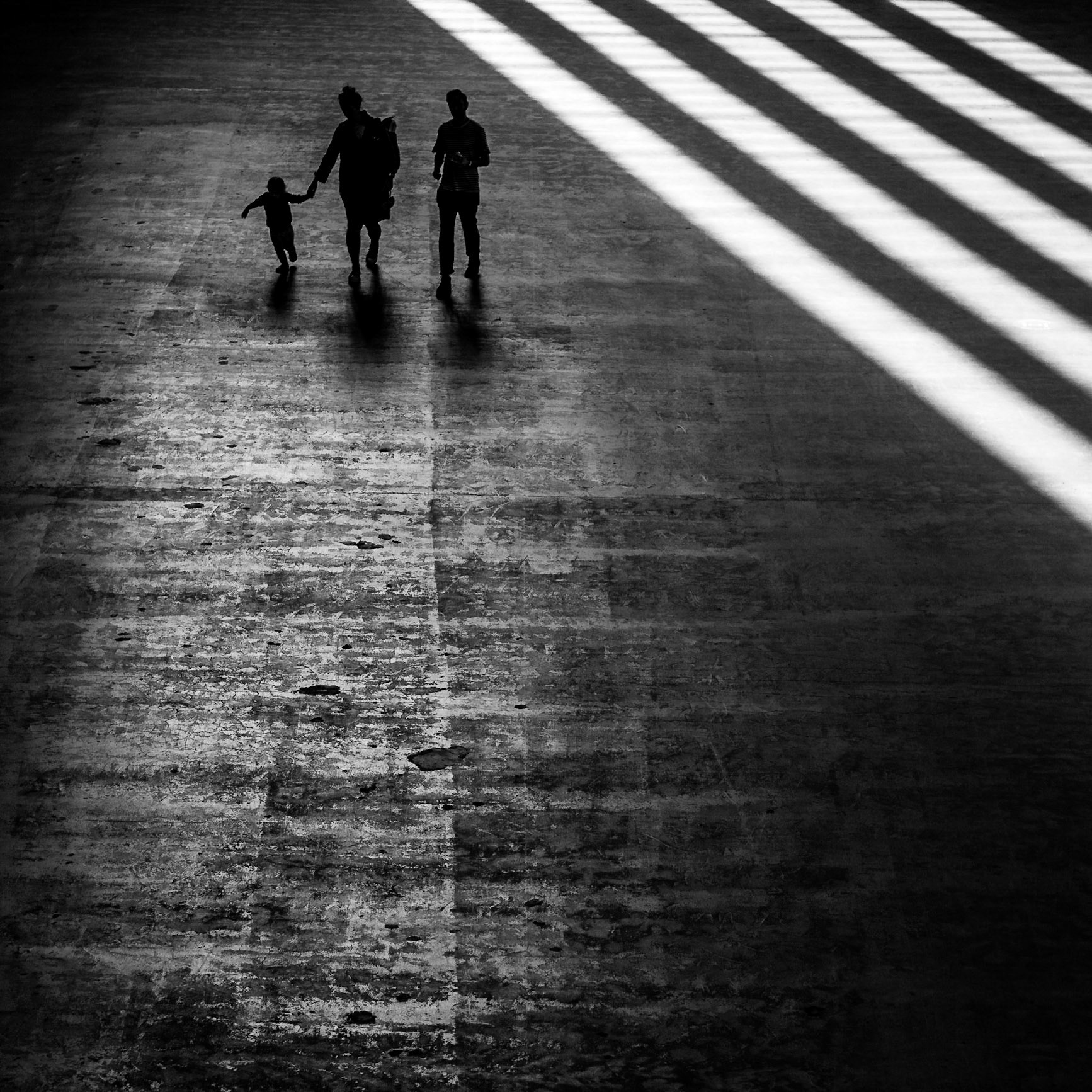 A young family enter the Tate Modern down the imposing ramp of the Turbine Hall