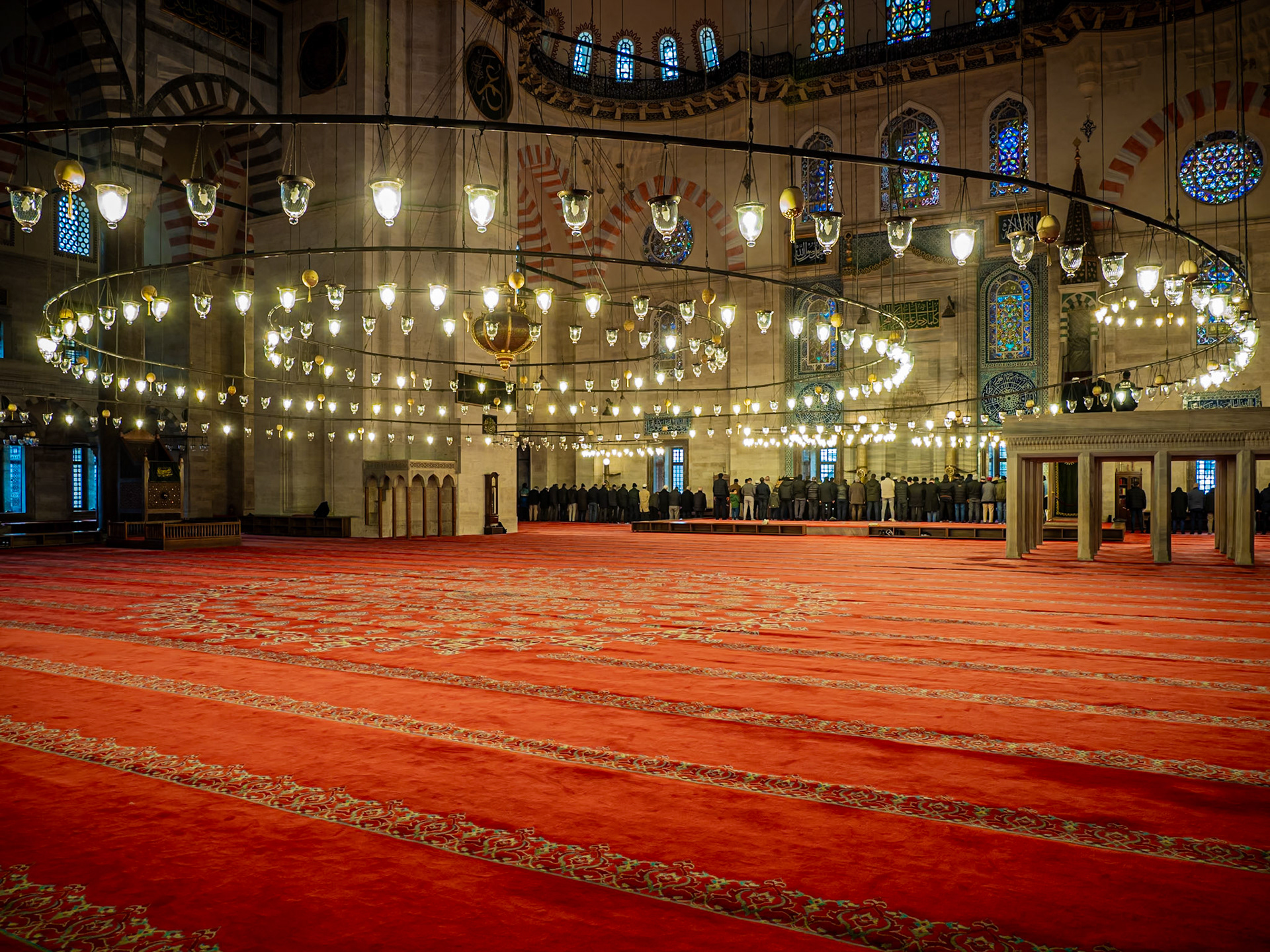 Vast circular lamps cast light on worshippers conducting Asr prayers late in the afternoon at the Suleymaniye Mosque in Istanbul