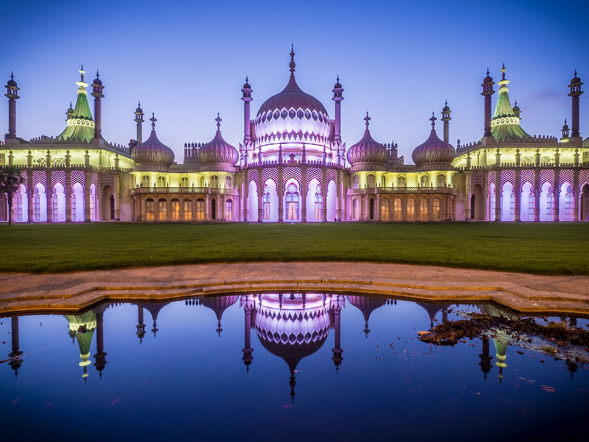 Floating plants creep into the reflection of the beautiful Royal Pavilion in Brighton as dusk falls