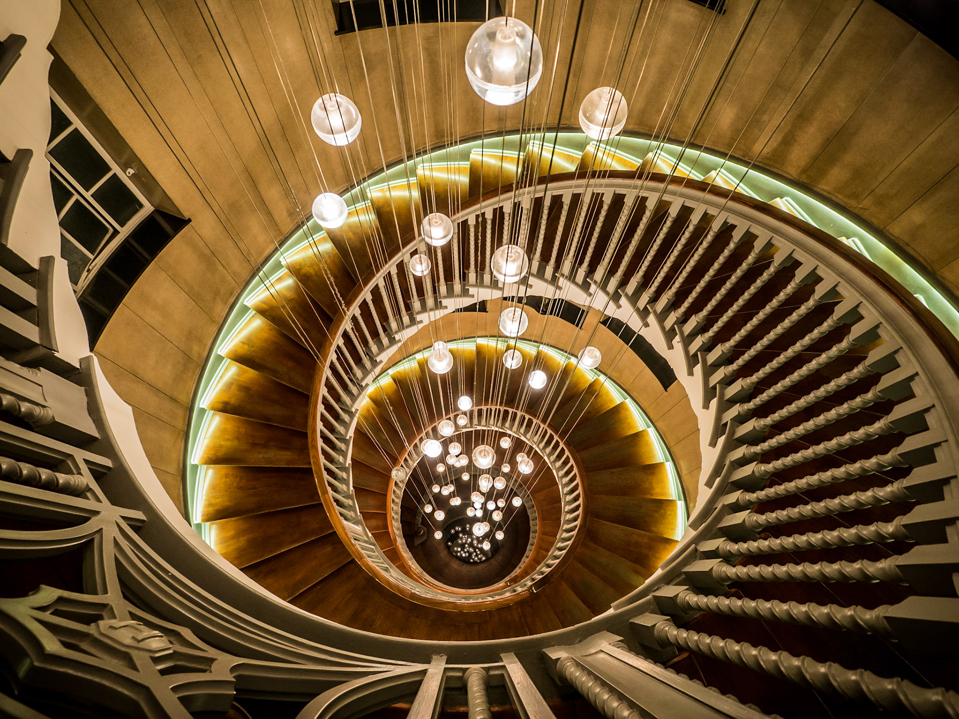 Globe lights cascade down the centre of the Brewer staircase in the Heals Building, London
