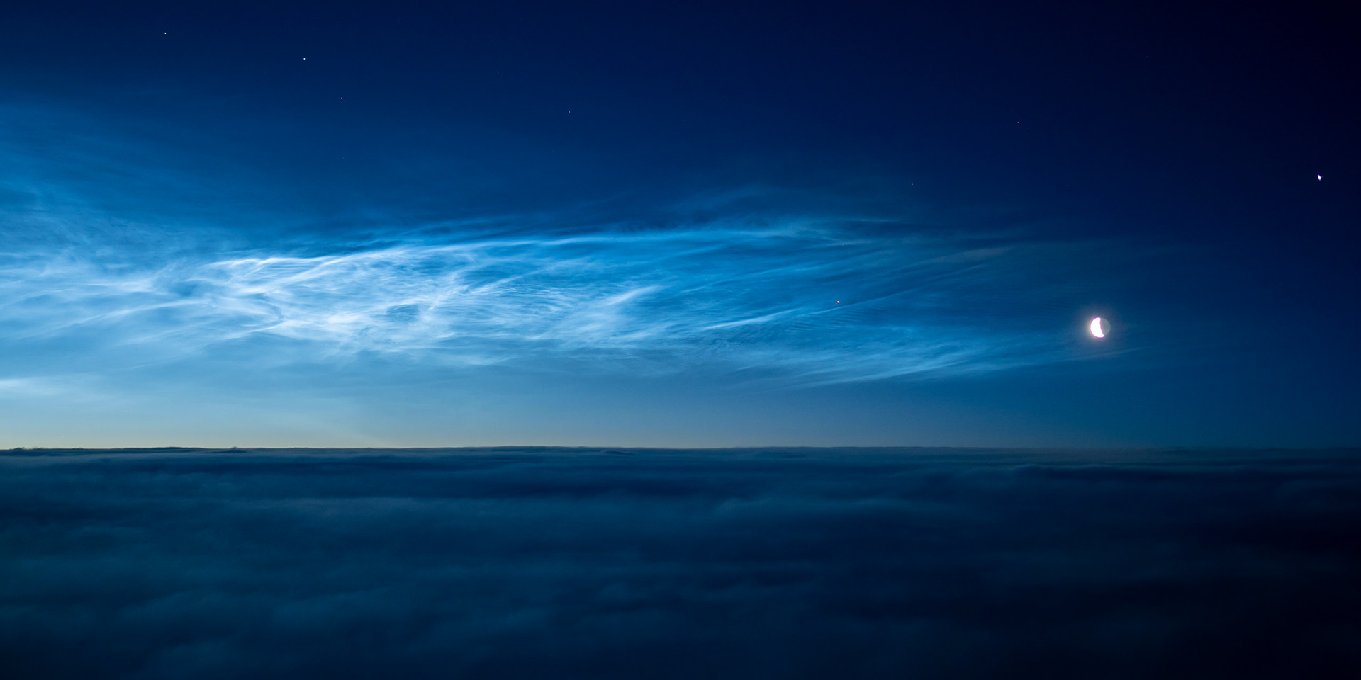 The moon and the planet Venus captured alonside stunnng noctolucent clouds
