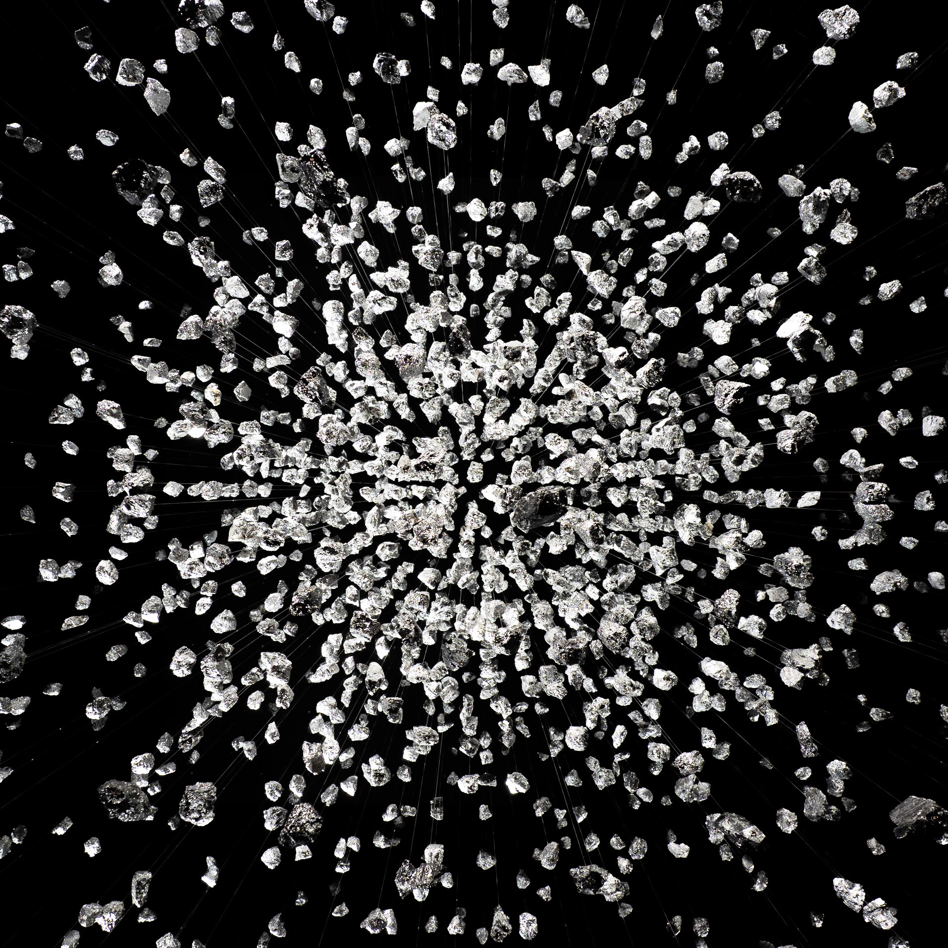 A torrent of rocks fall from the ceiling of a contemporary art installation