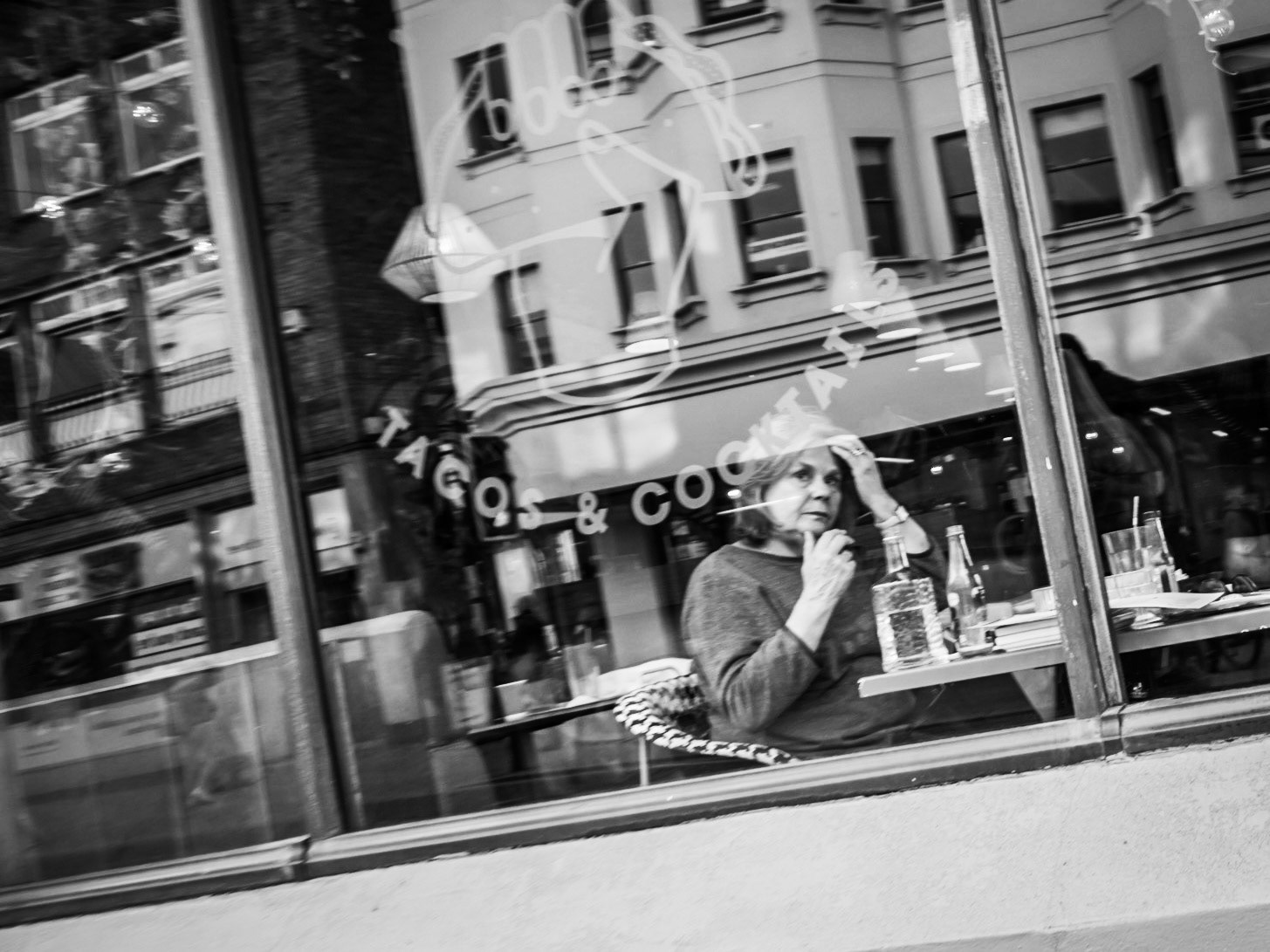 A woman catches me taking  her picture through the window of restaurant in Brighton