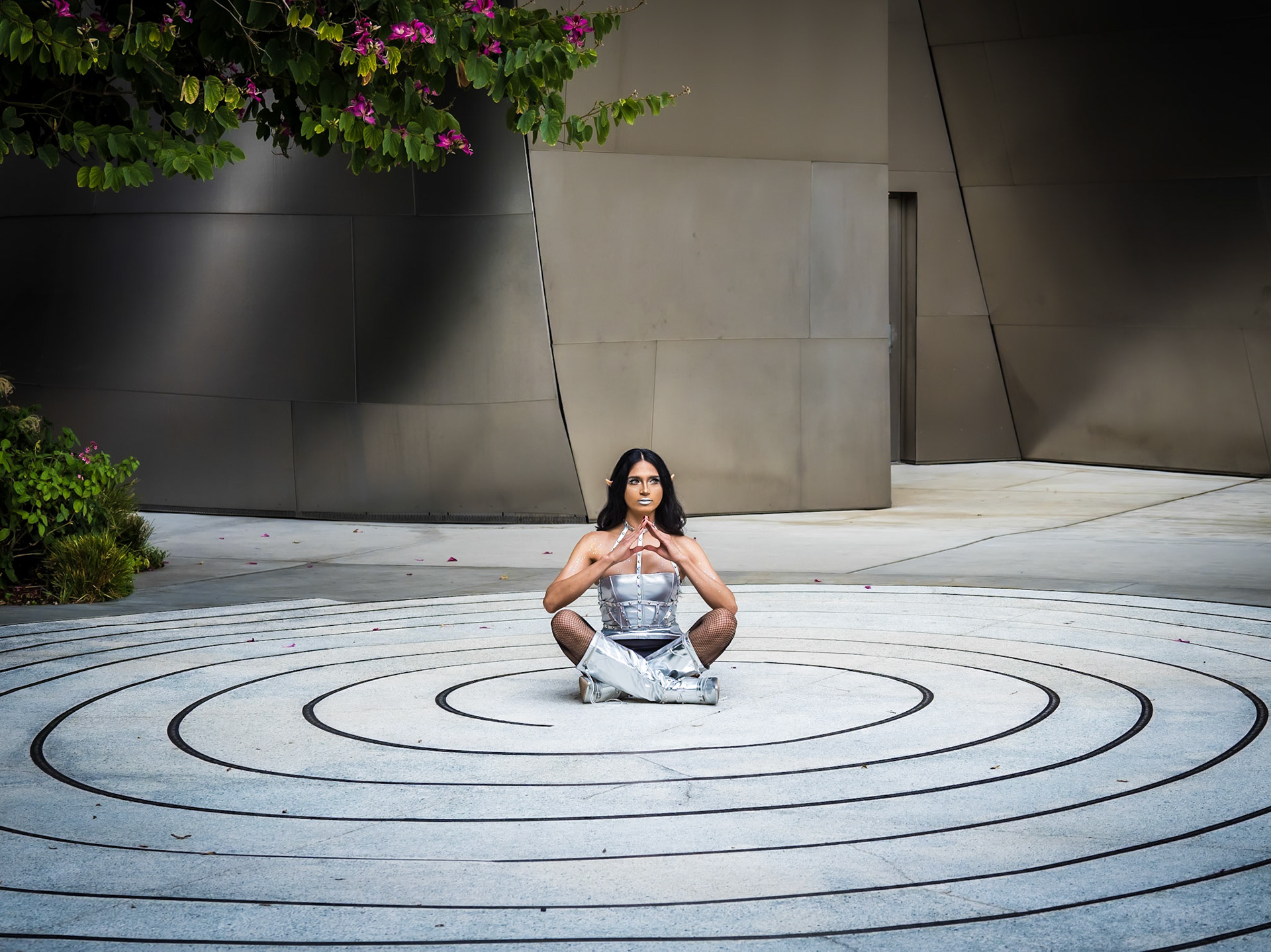 A cosplay fan poses whilst sitting in a spiral marked on the gounds of the Wal Disney Theatre in downtown Los Angeles