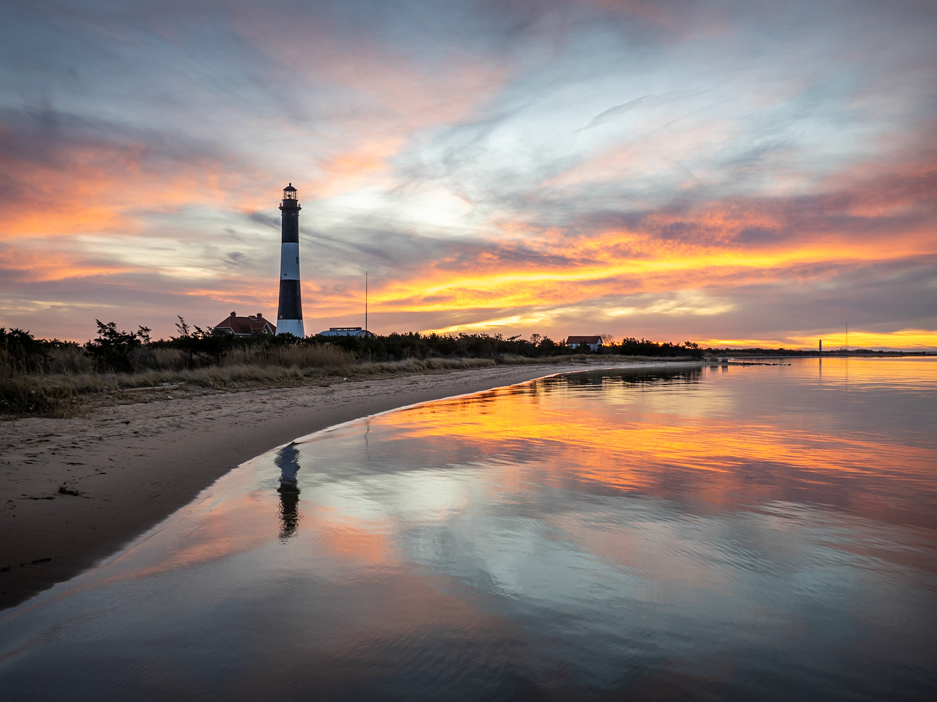 The skies behind the lighthouse on Fire Island match the island's name, alight with vivid colours as the the sun sets