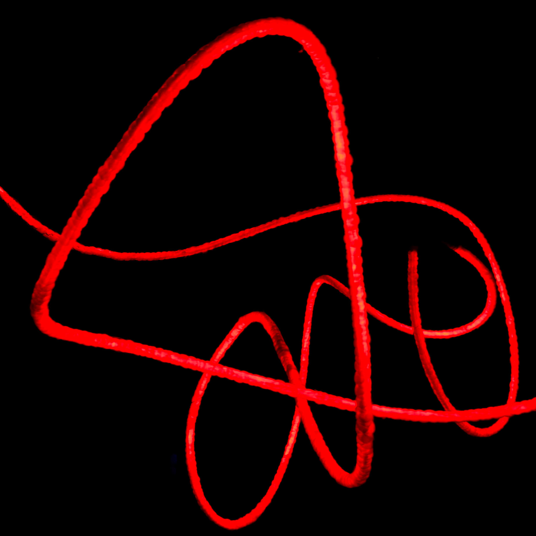 Red rope hangs mid-air in the darkness of night