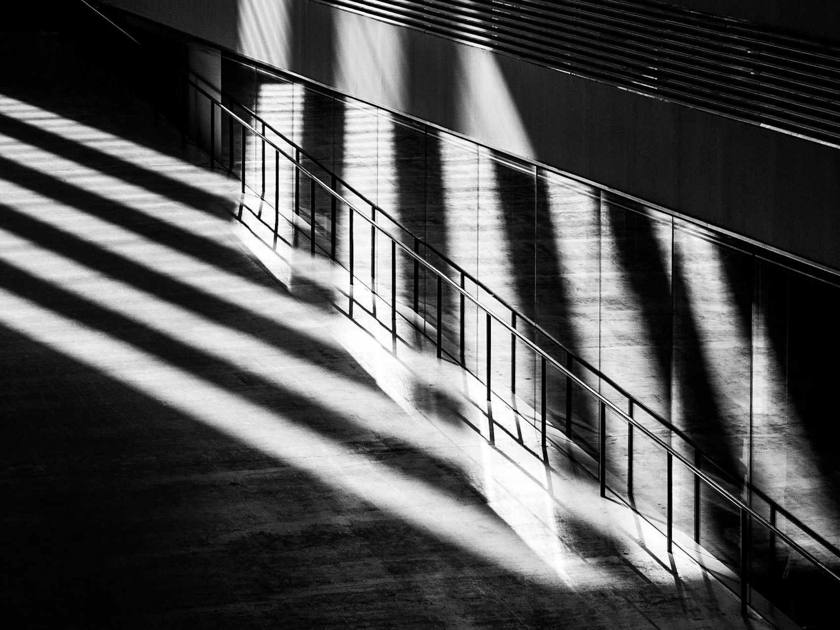 The sun casts striking shadows along the slope of the huge Turbine Hall of the Tate Modern