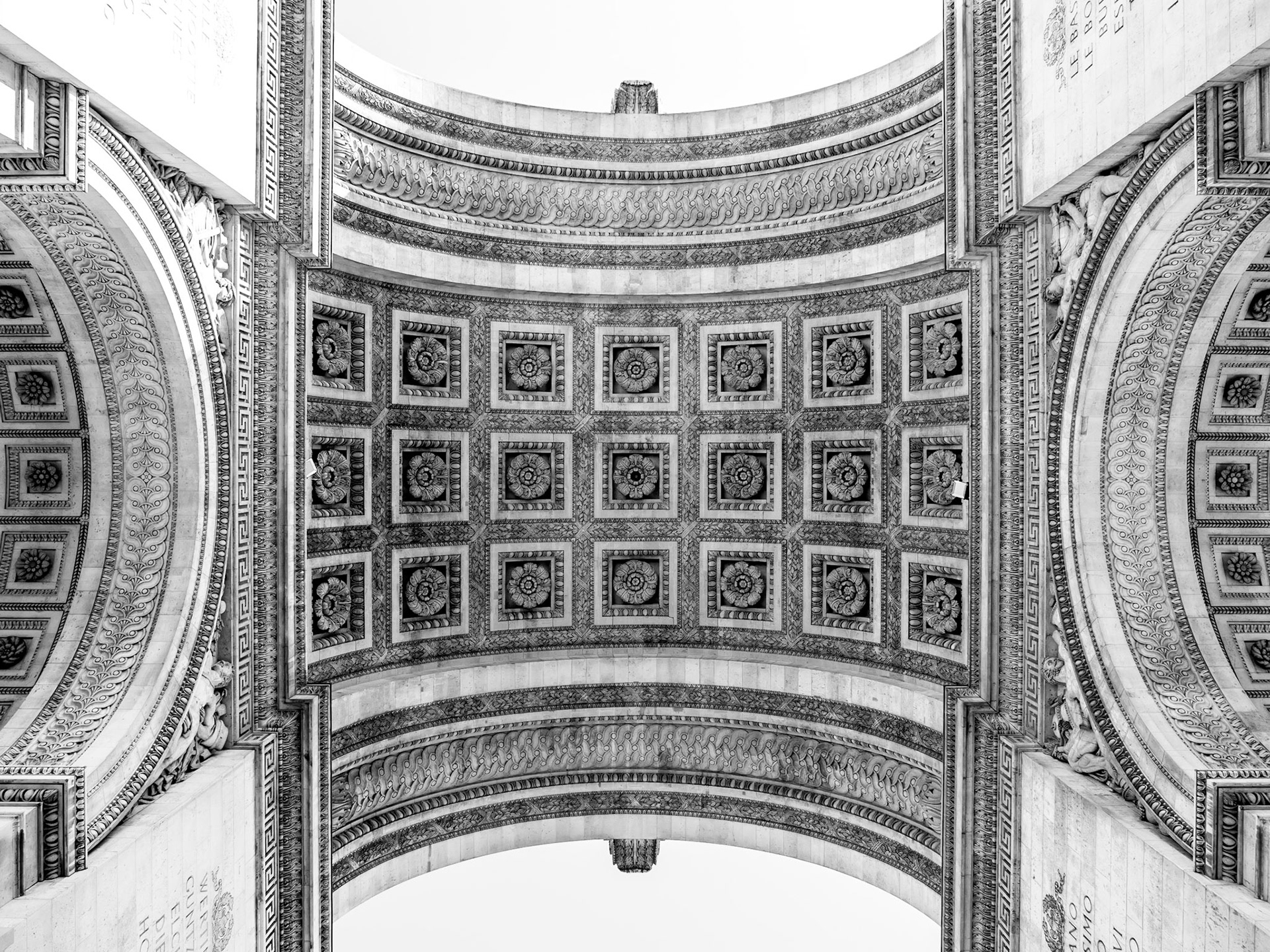 The intricate stonework adorning the ceiling of the Arc de Triomphe in Paris