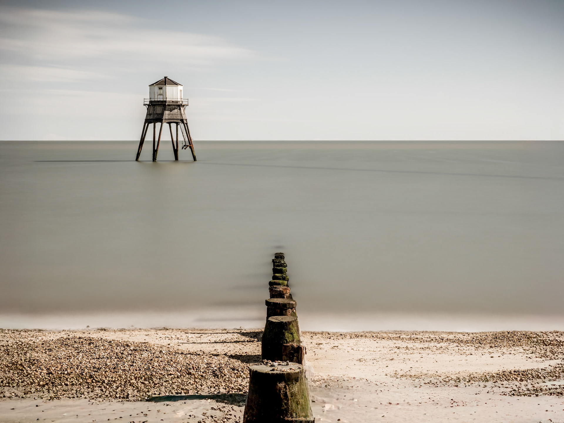The lower lighthouse on Dovercourt Beach in Essex stands solitary in a clam sea