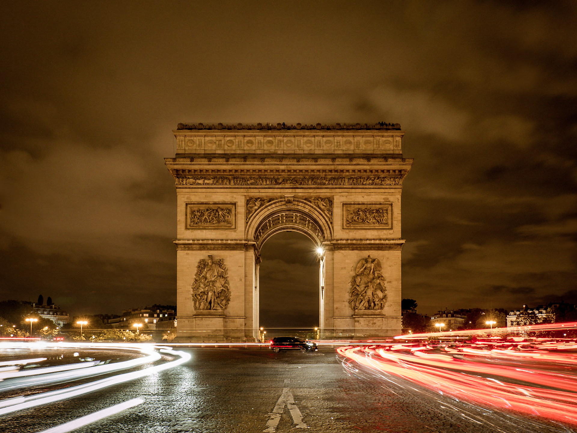 Traffic continues to revolve endlessly around the Arc de Triomphe in central Paris, despite the late hour