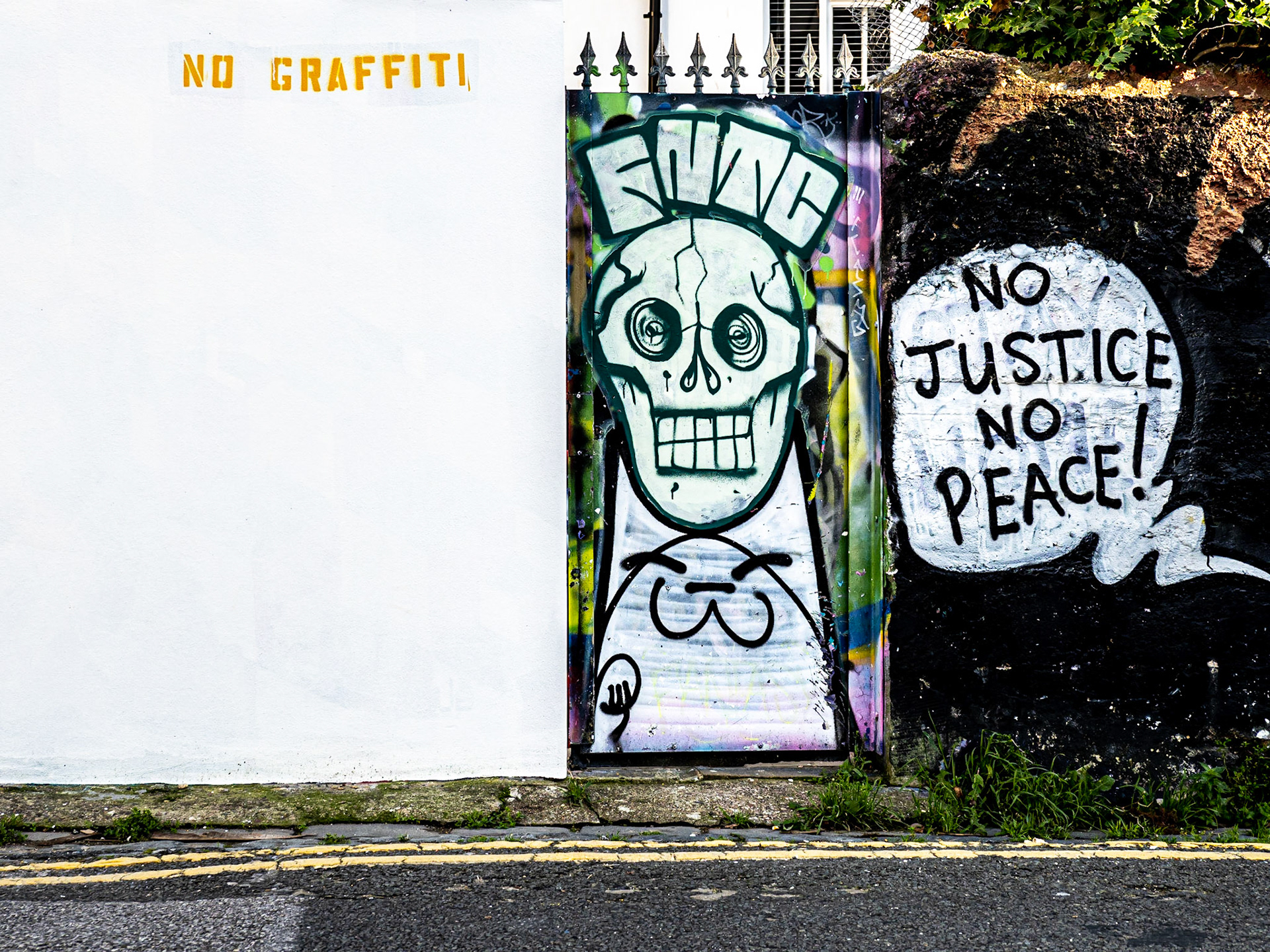 A clean wall butts, tongue in sheek, against a vivid image of a skull and a pup in Brighton's famous Trafalgar Lane