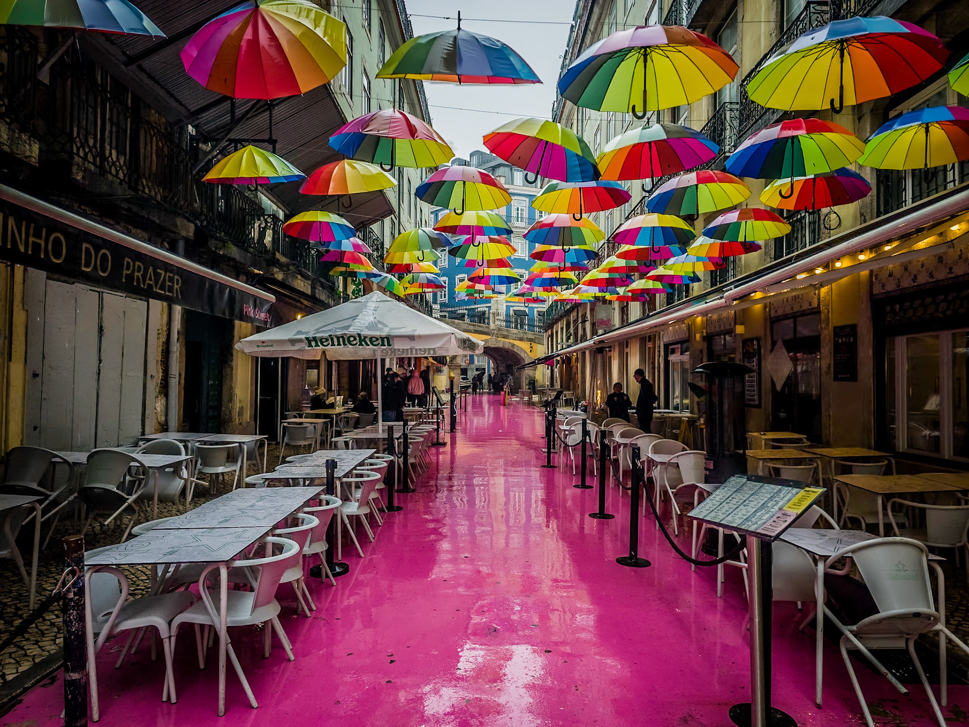 The brightly painted pavement and a canopy of colourful umbrellas bring vibrant life to Lisbon’s famous Pink Street