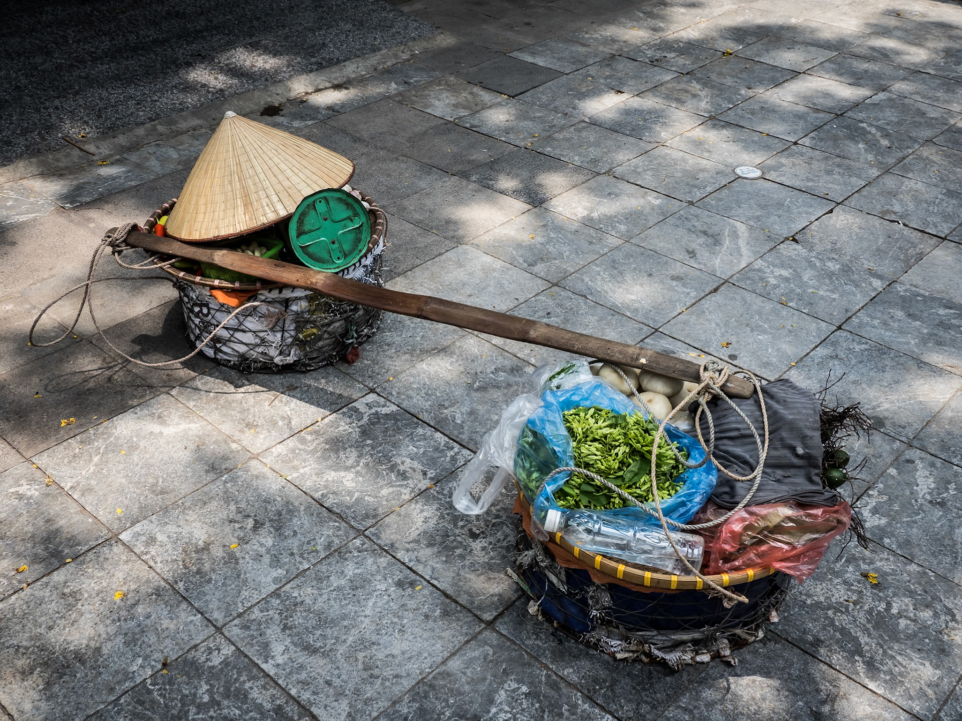 A street seller's Vietnamese Non La 'Leaf Hat' sits with her wares on a back street in the central Hanoi