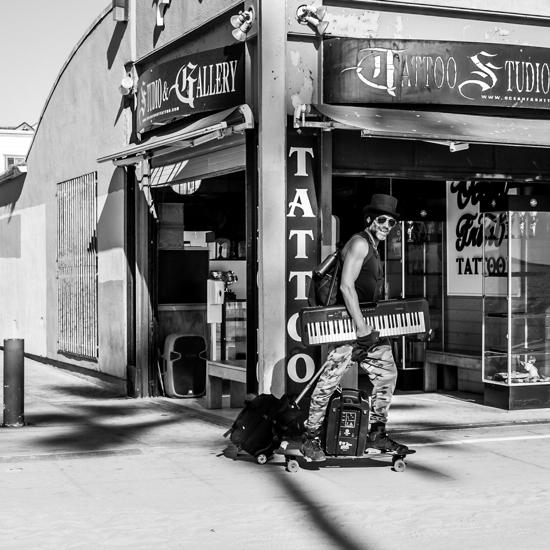 A busker carries himself and his musical equipment on a skateboard on  the way to start his busking session on Venice Beach