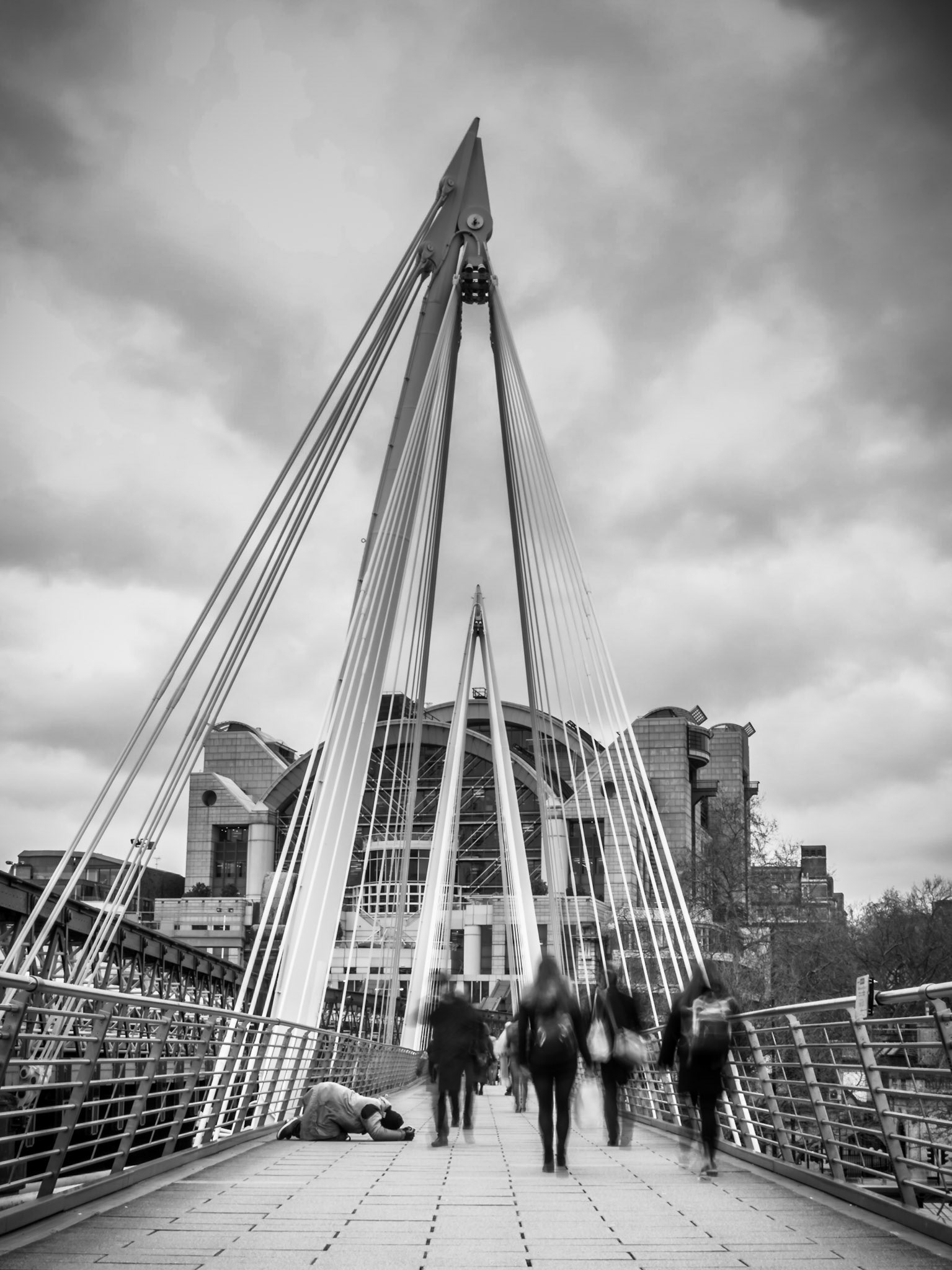 A homeless man begs for change as commuters pass by during rush hour in London