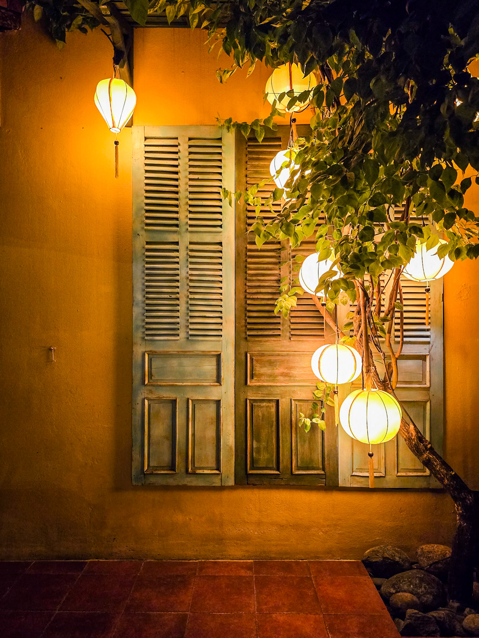 Traditional Vietnamese lanterns cast a calming glow against a shuttered window