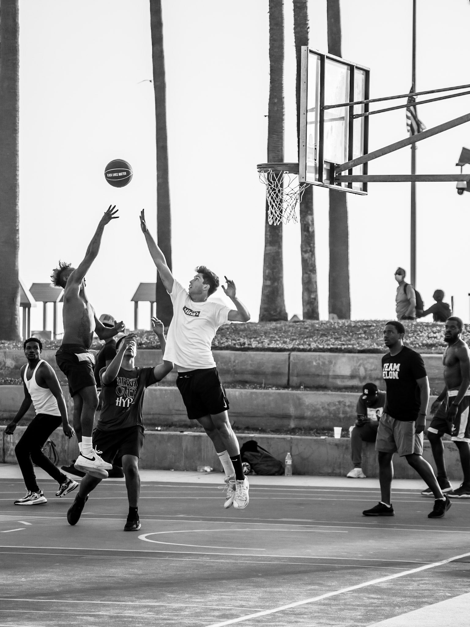 Locals play basketball on Venice Beachfront as the sun sets