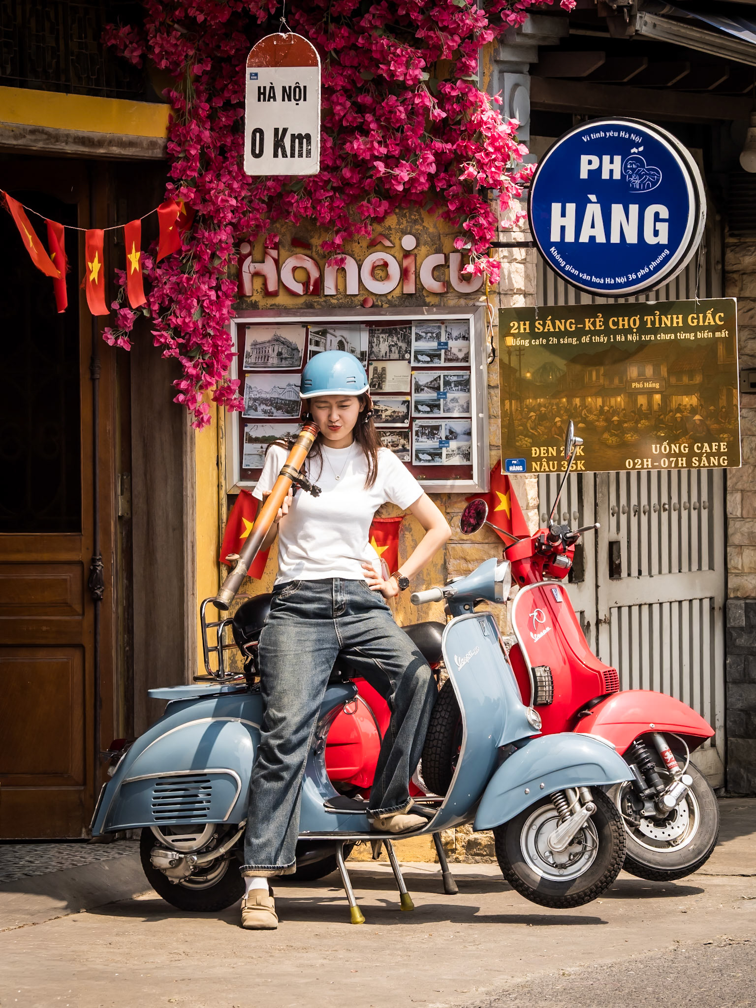 On a back street in Hanoi, a model poses with a pair of vintage mopeds for a photoshoot