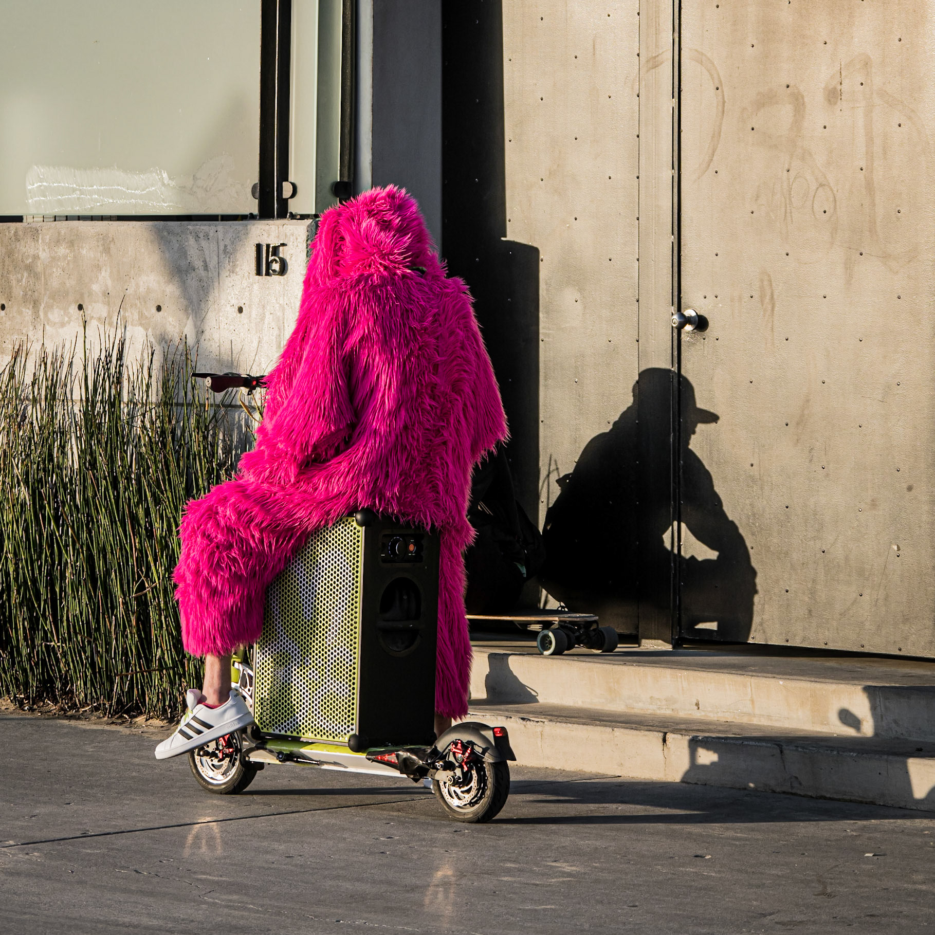 The disconnected shadow of a local resident in vivid pink on a boomtastic scooter on Venice beachfront