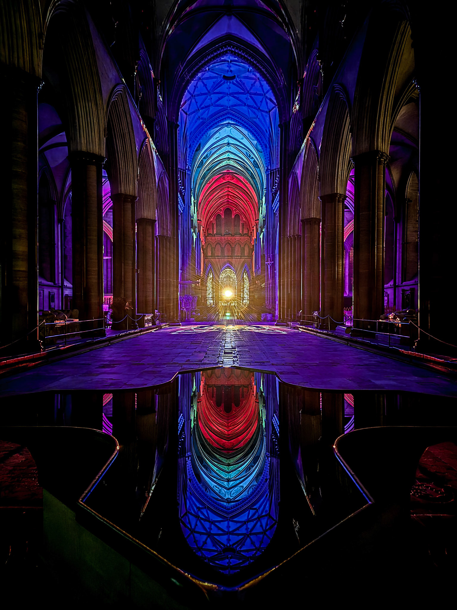 Before the annual Sarum Lights festival begins, vibrant colours reflect off the still water of the unique font in an empty Salisbury Cathedral