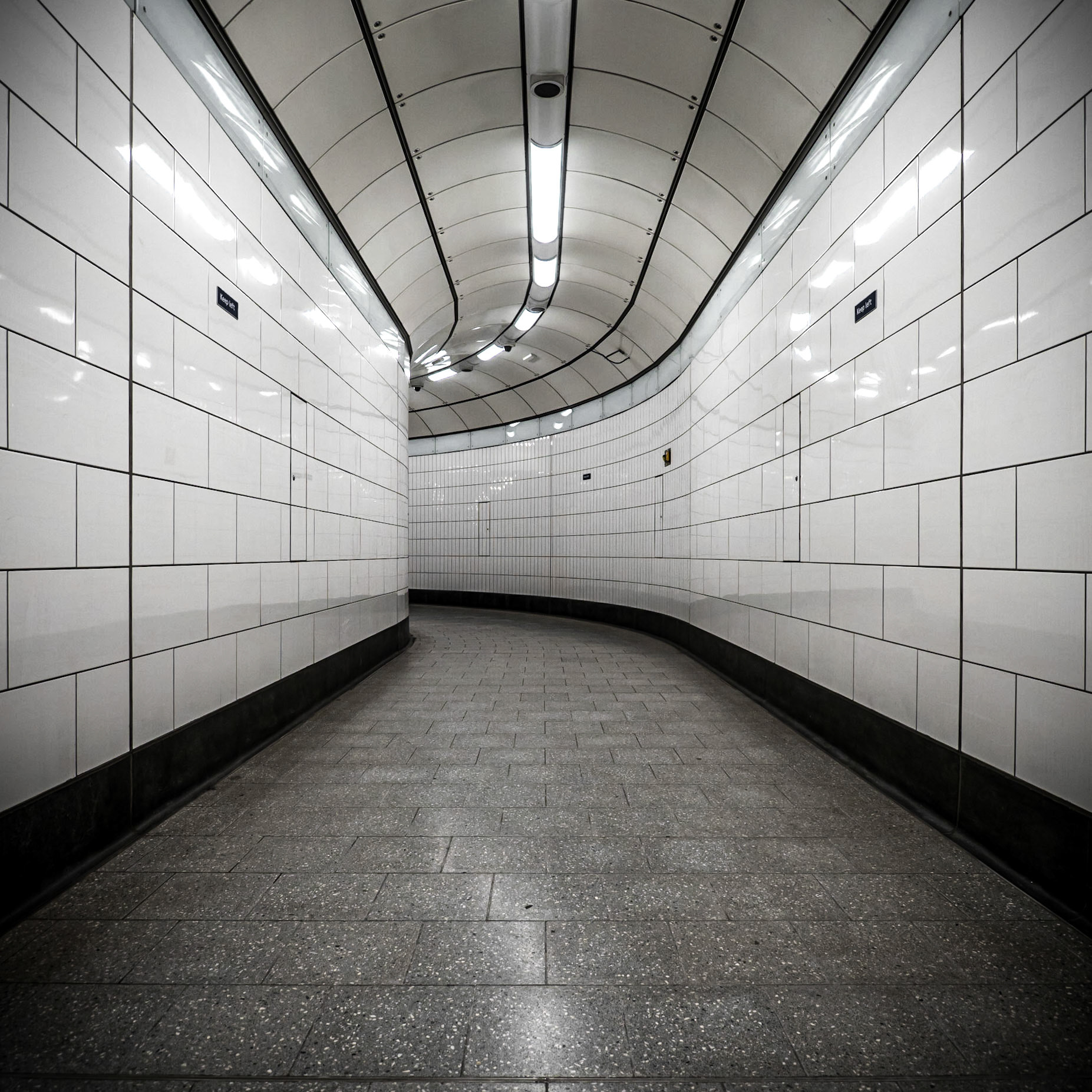 A new tunnel with a clinical feel at Tottenham Court Road station waits to lead commuters through their journey onto the the Crossrail extension in Central London