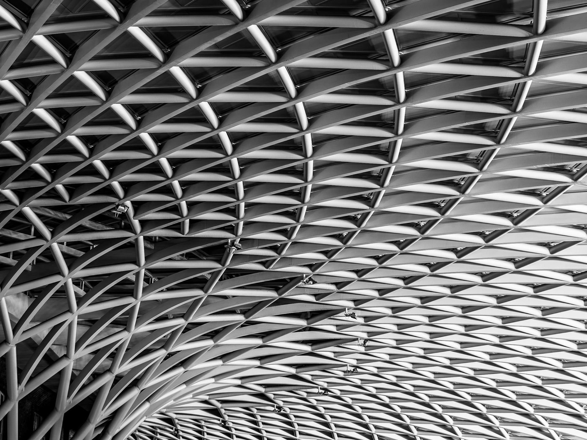 The ceiling of Kings Cross train station flows upwards from the concourse floor