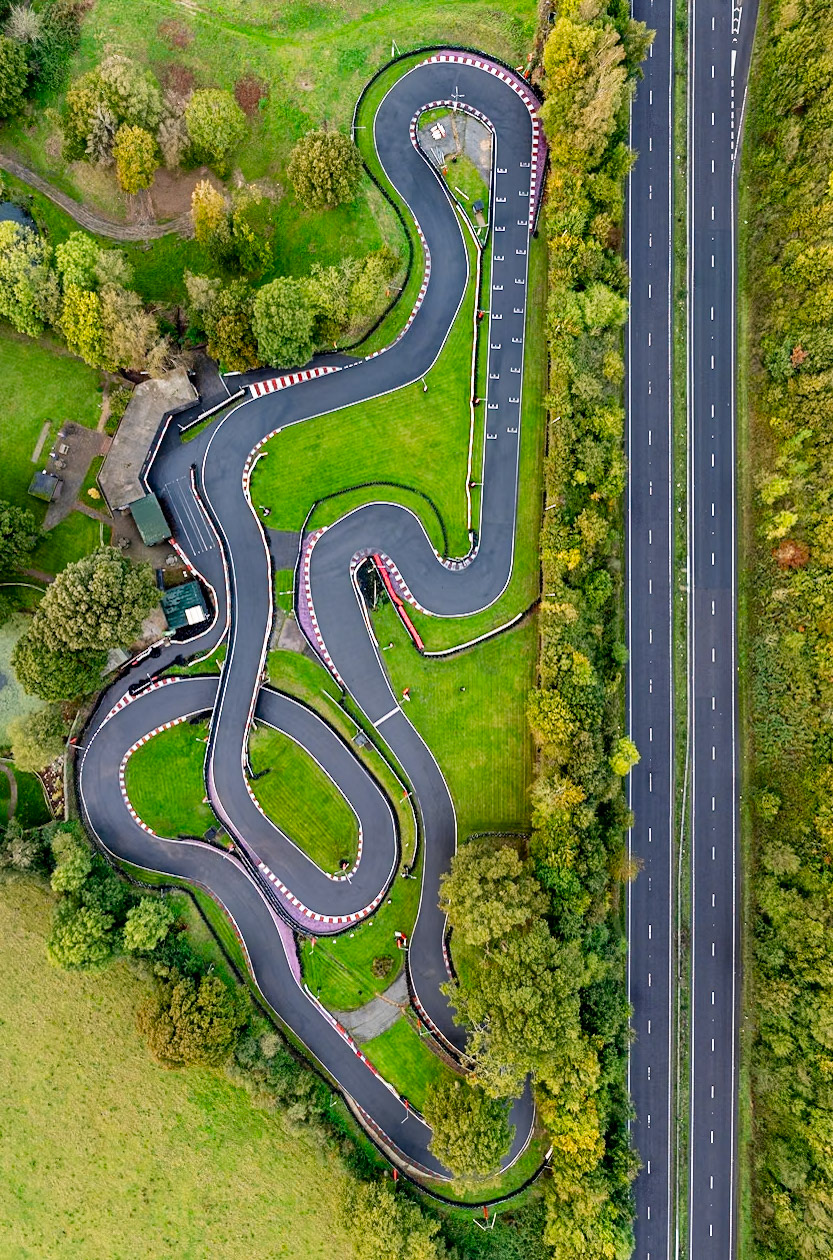 An empty race track nestled in trees beside a main road in Southern England