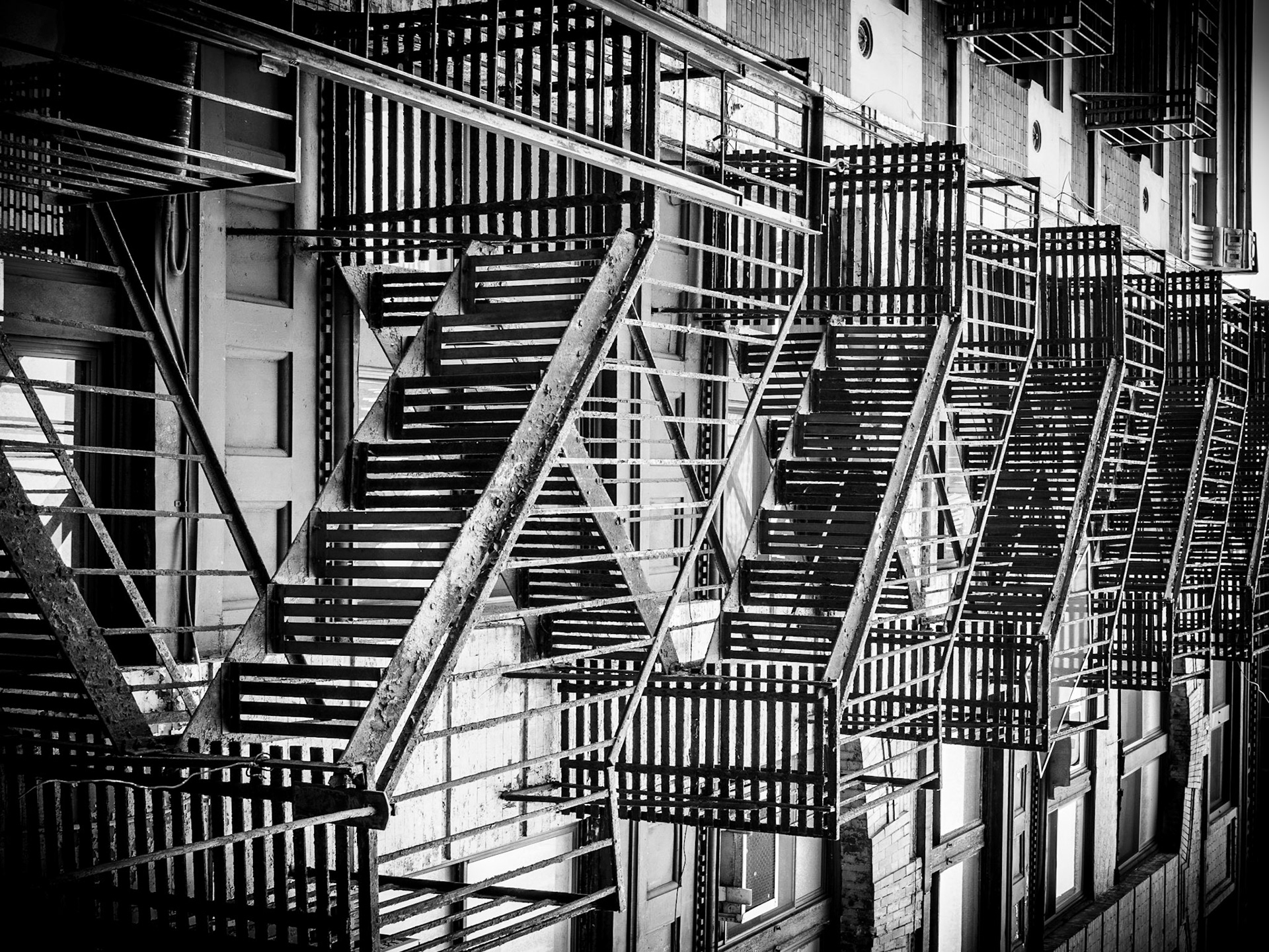Fire escapes along the ide of brownstone buildings in the Canal Street district of Manhattan, New York