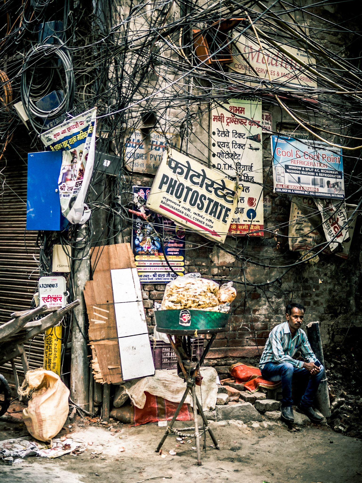 Cables and wires converge above a street-seller in the Chandni Chowk district of New Delhi