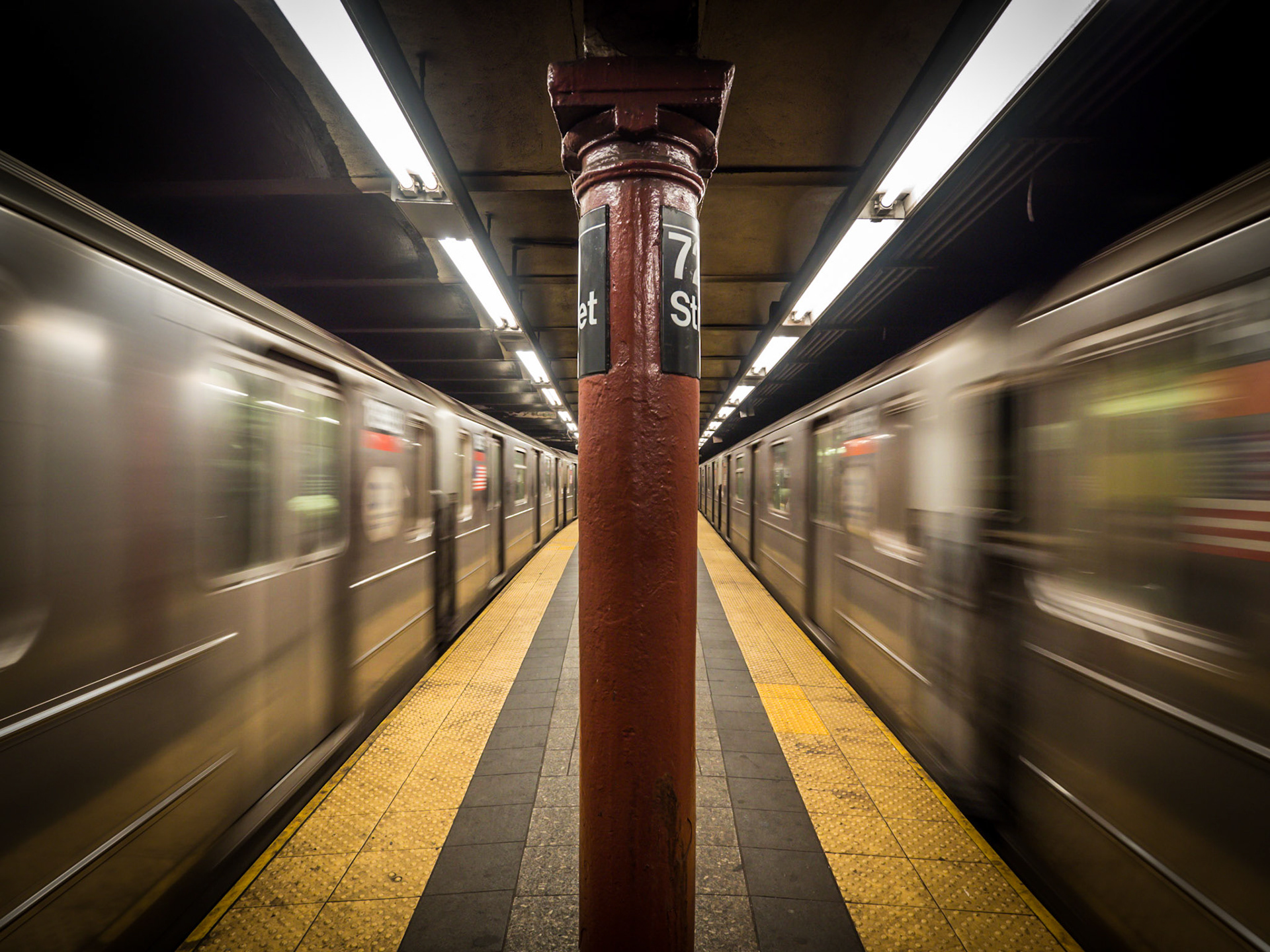 Subway cars rush away from the platform during an evening rush hour in Manhattan, New York