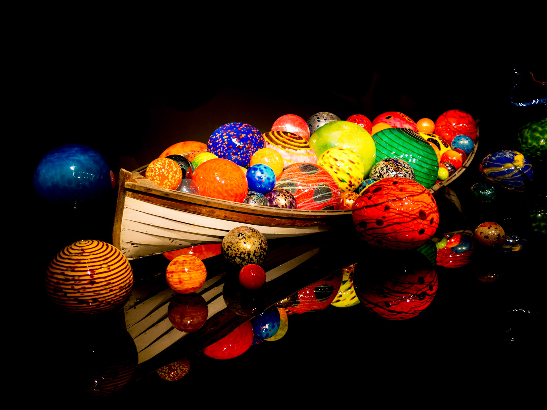 Colourful glass orbs fill an ancient rowing boat