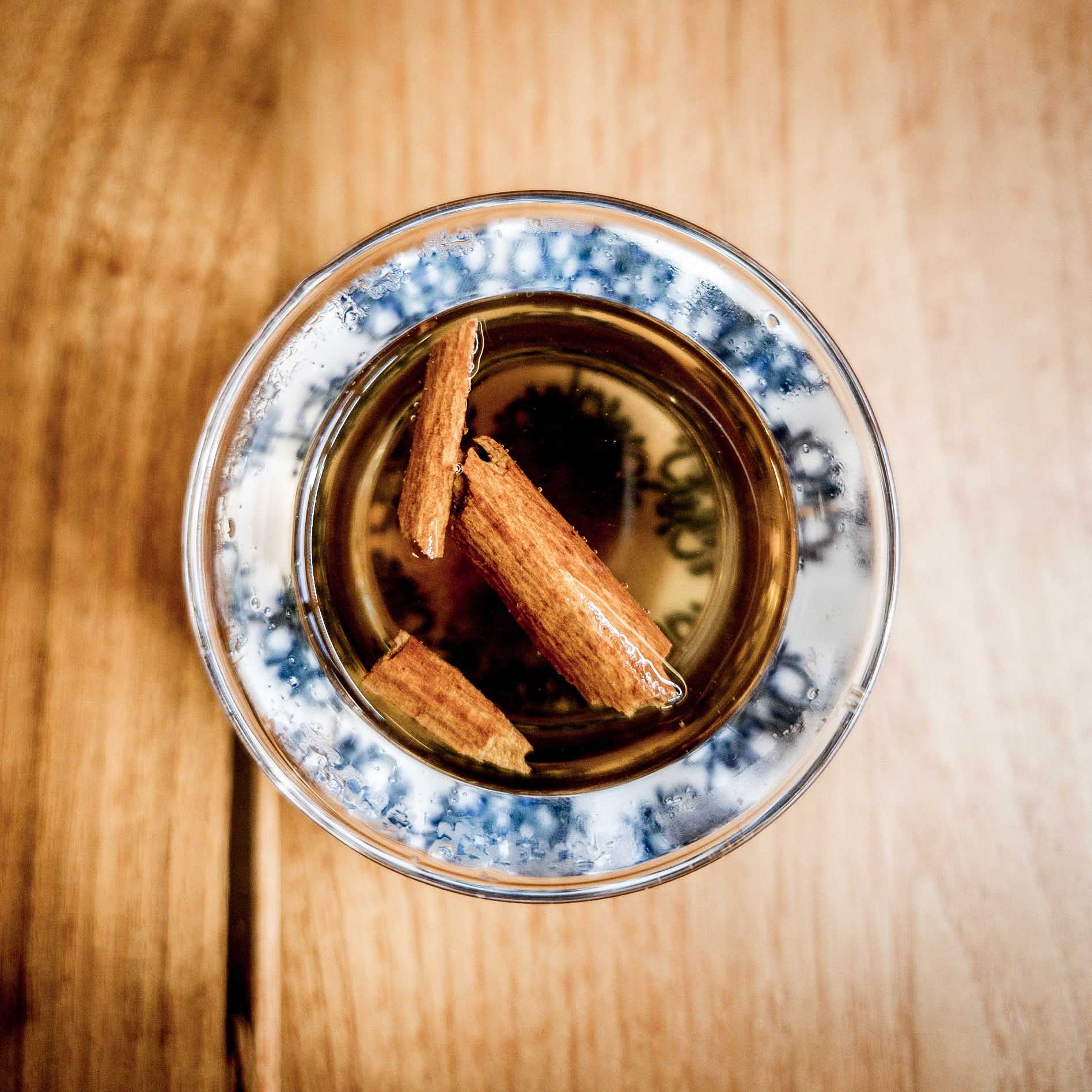 Cinanamon sticks float at the top of a glass cup of Turkish apple tea