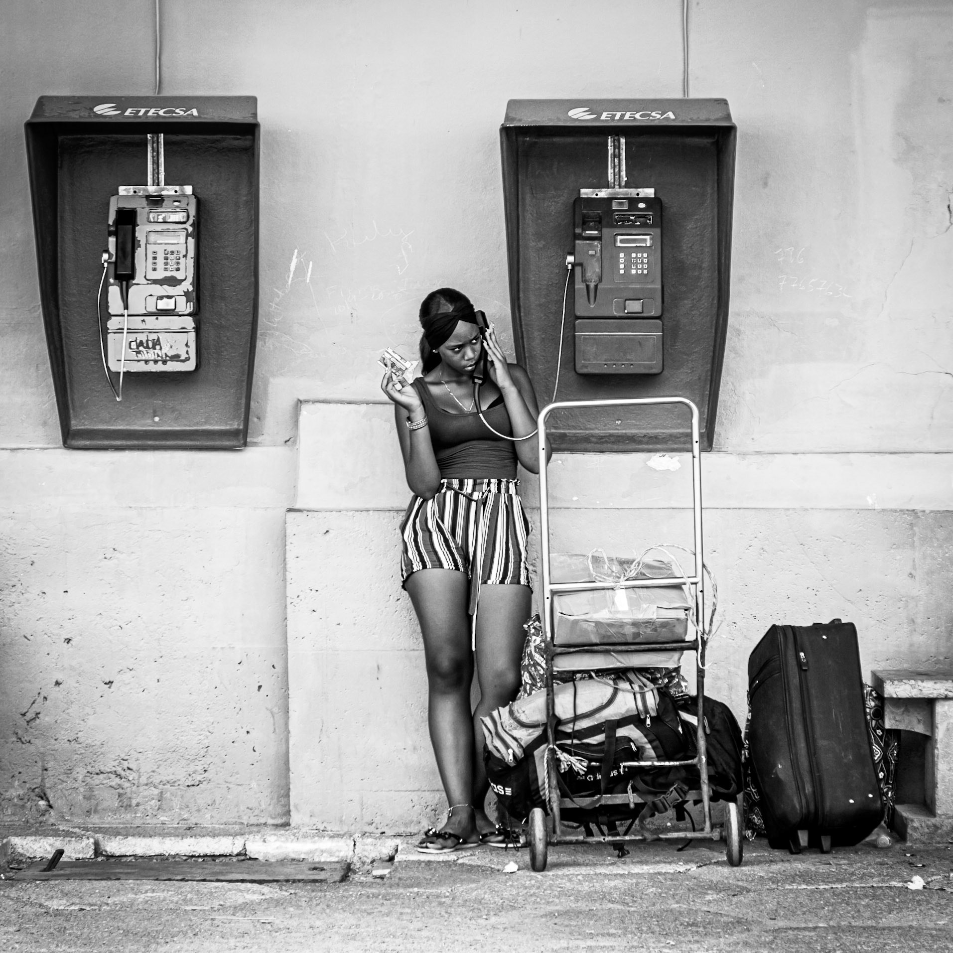 Making a final telephone call before catching her train, a girl uses a phone card at a payphone at Havana train station