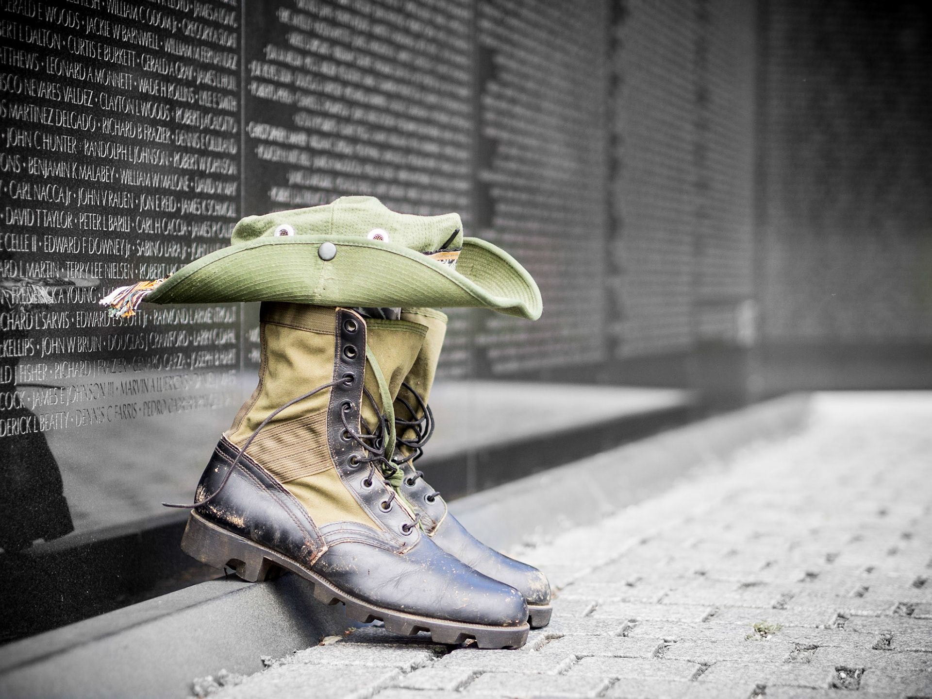 A lone pair of boots sit next to a long list of fallen soldiers in Washington DC
